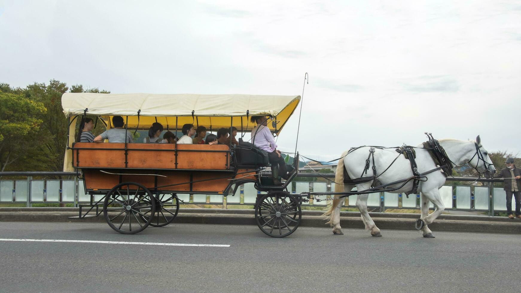 yufuin, oita, kyushu, japón - octubre 14, 2018 el turista en el caballo carro paseo alrededor Yufuin, río y Yufu montaña antecedentes foto