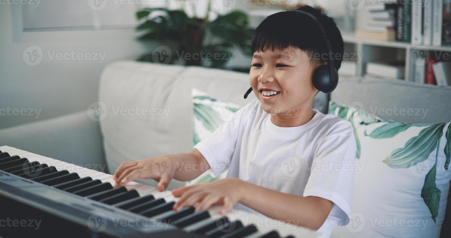 Cute boy enjoy to learning playing piano at home photo