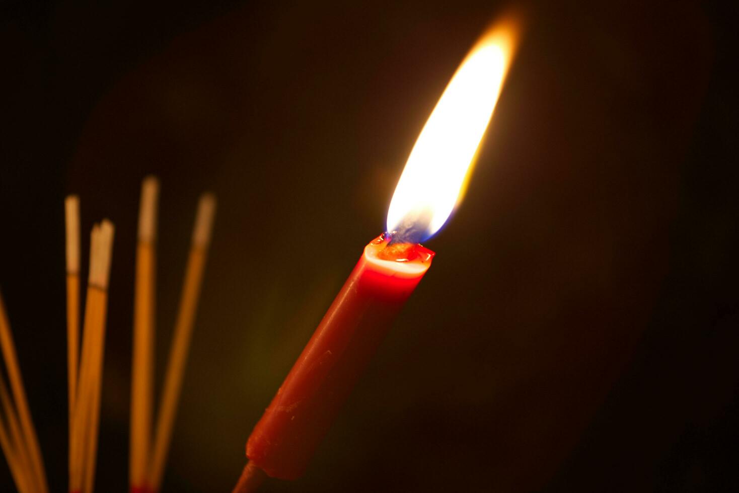 burning Incense and red candles to pay homage on a dark background during Hungry Ghost Festival pay homage to their deceased ancestors photo