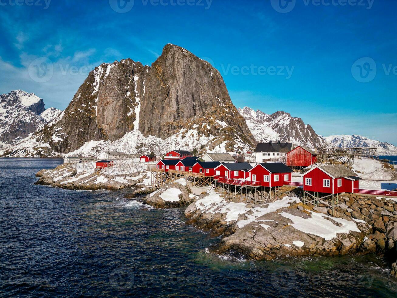 Red fishing cabins in Lofoten Norway by drone, rorbuer snow mountain photo