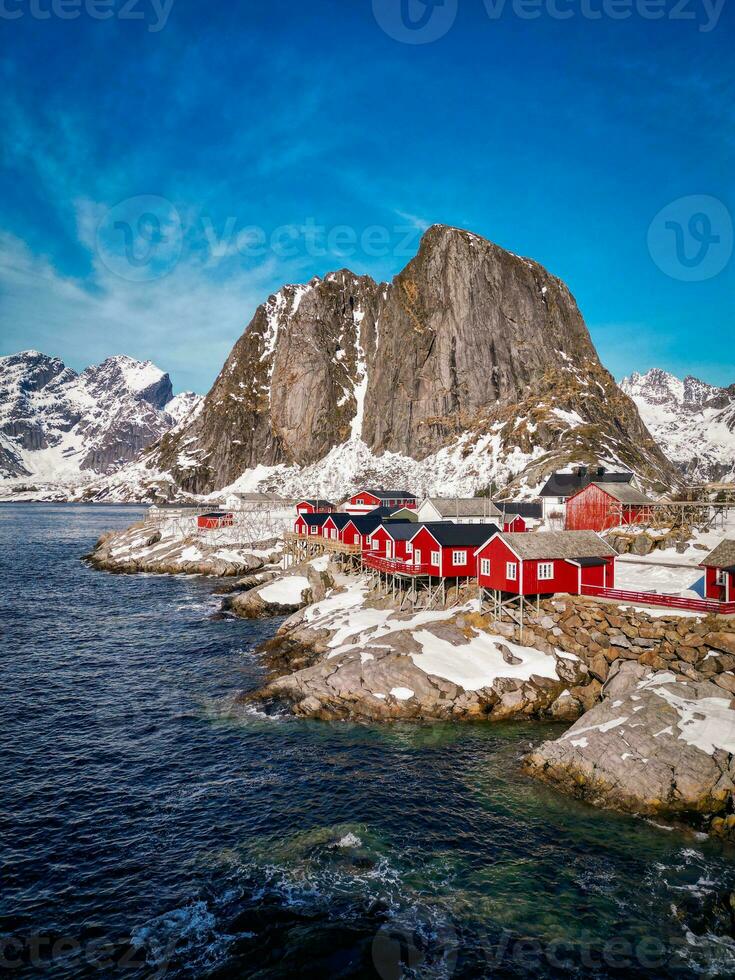 Red fishing cabins in Lofoten Norway by drone, rorbuer snow mountain photo