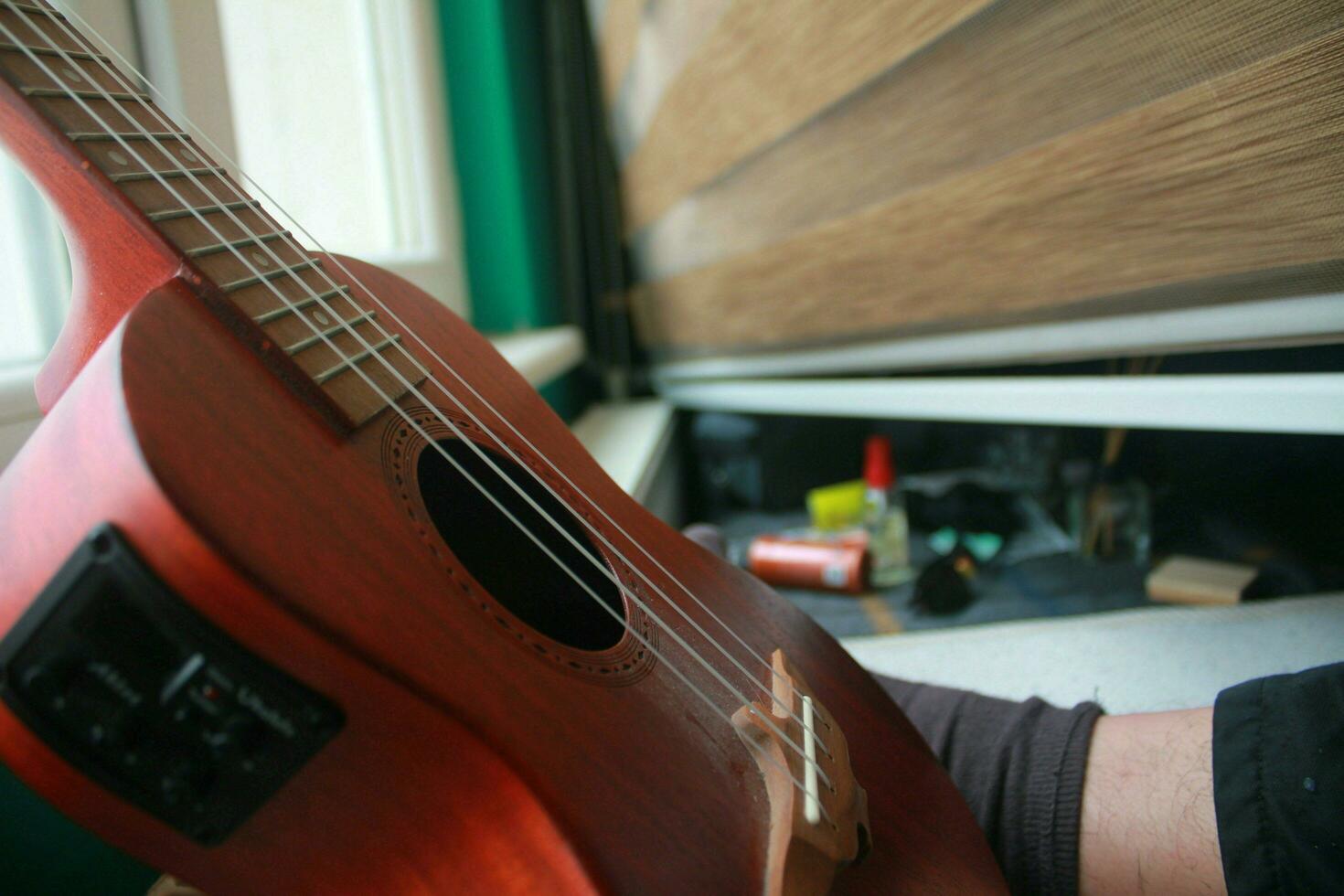 Ukulele guitar leaning against window as it finishes playing, May 7, 2023 Turkey photo
