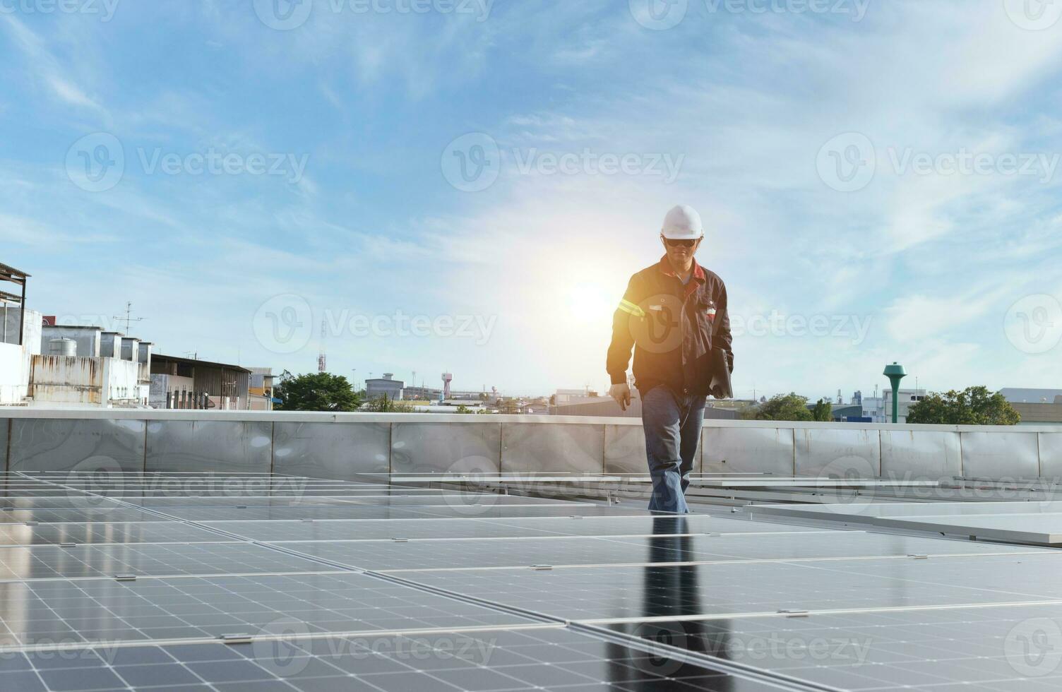 technician inspecting solar panels on factory roof Check and maintain the solar panel roof A team of technicians installing solar panels on the roof of a high-rise building photo