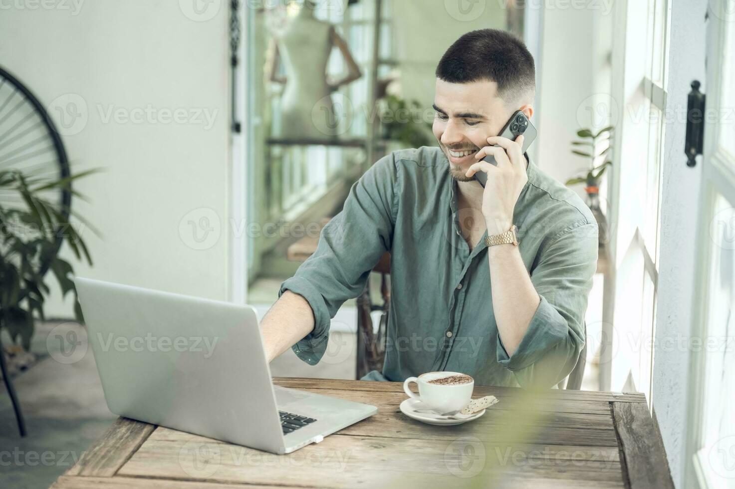 handsome young businessman Working on laptop and working online while sitting at coffee shop table, businessman working outdoors side view photo