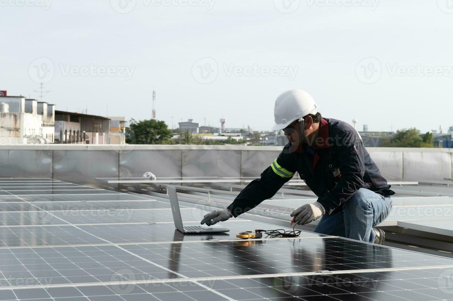 technician inspecting solar panels on factory roof Check and maintain the solar panel roof A team of technicians installing solar panels on the roof of a high-rise building photo