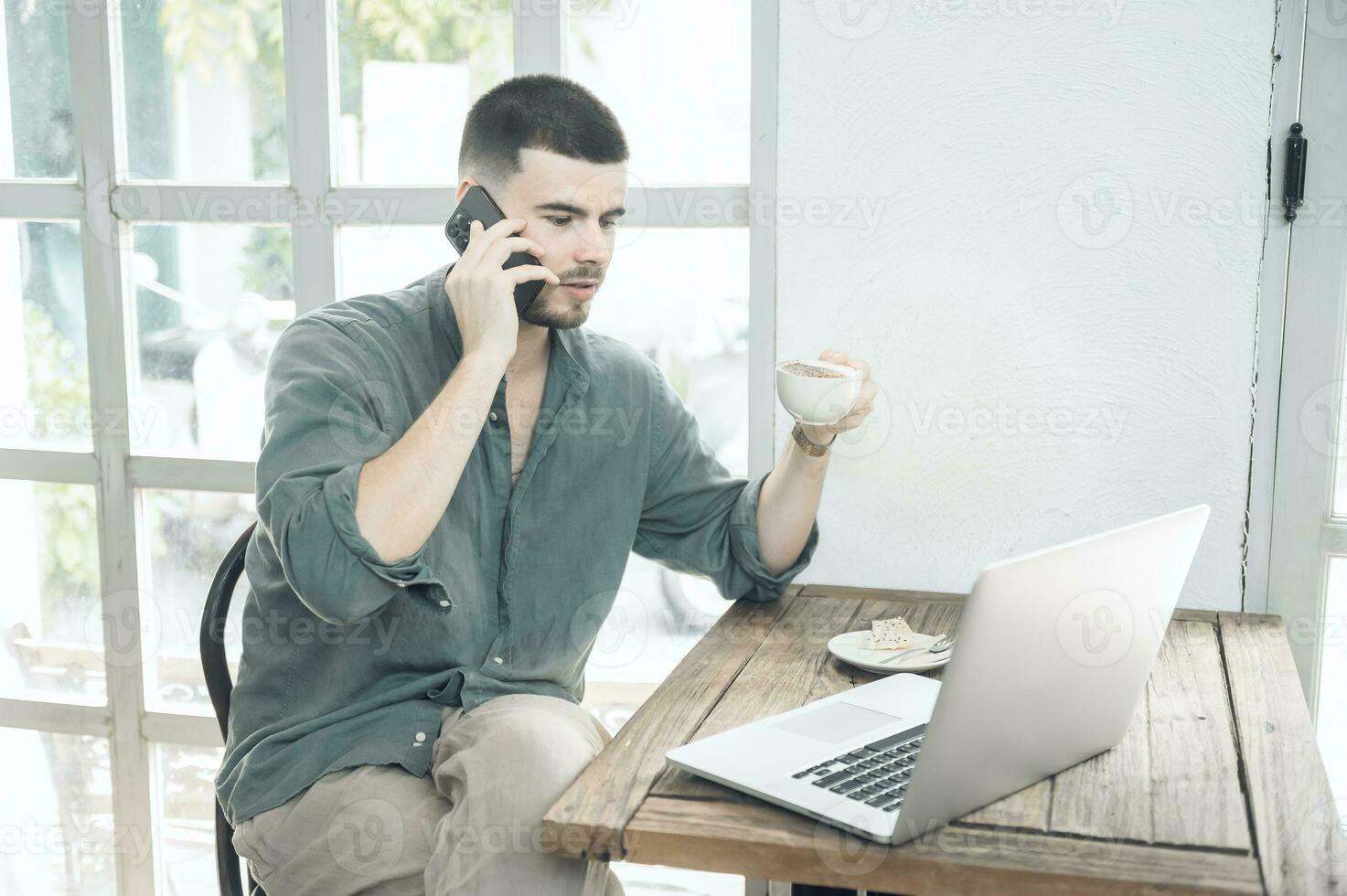 handsome young businessman Working on laptop and working online while sitting at coffee shop table, businessman working outdoors side view photo