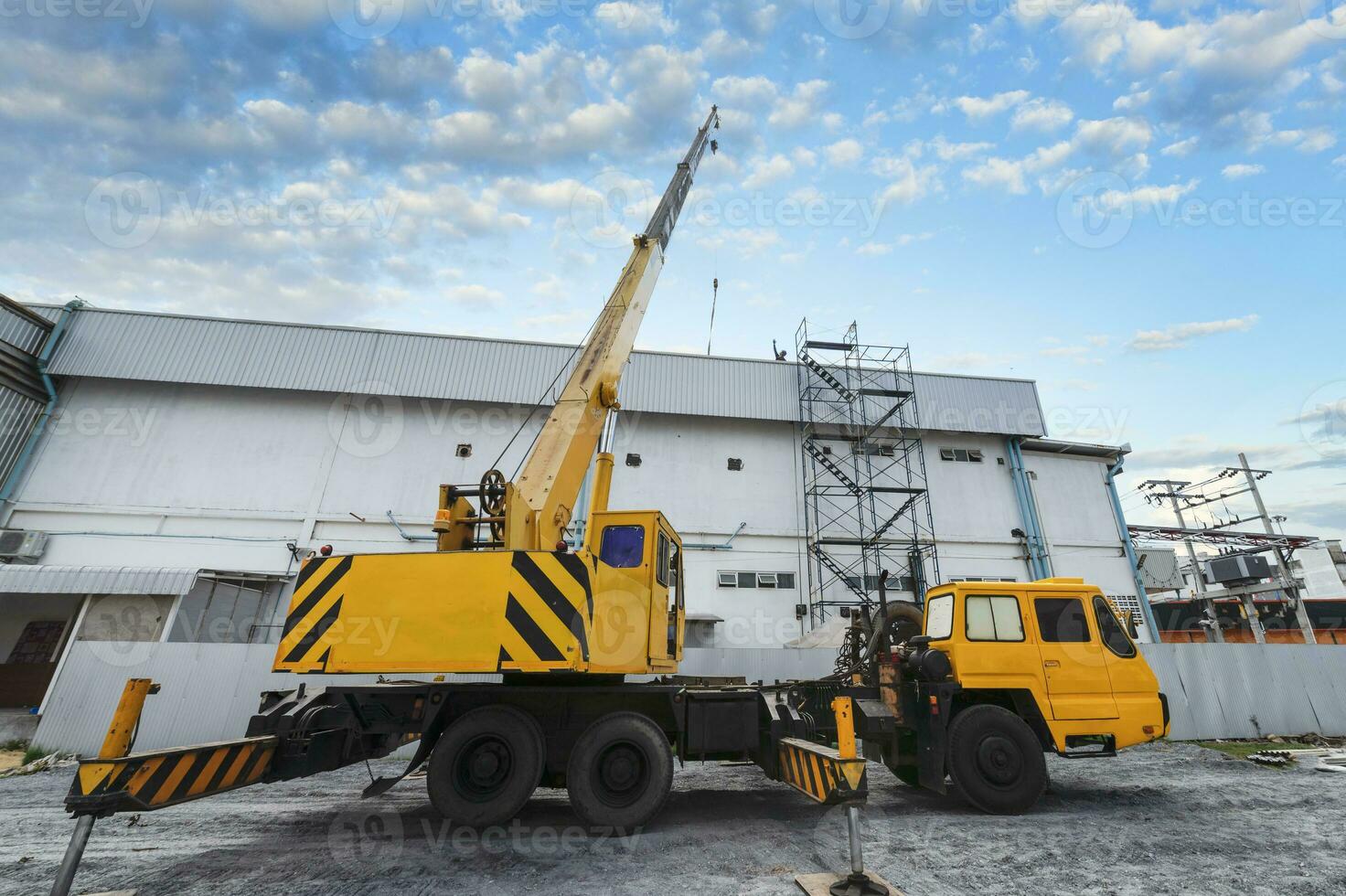 industrial grua trabajando y levantamiento poder generador debajo luz de sol y azul cielo, pesado equipo grua foto