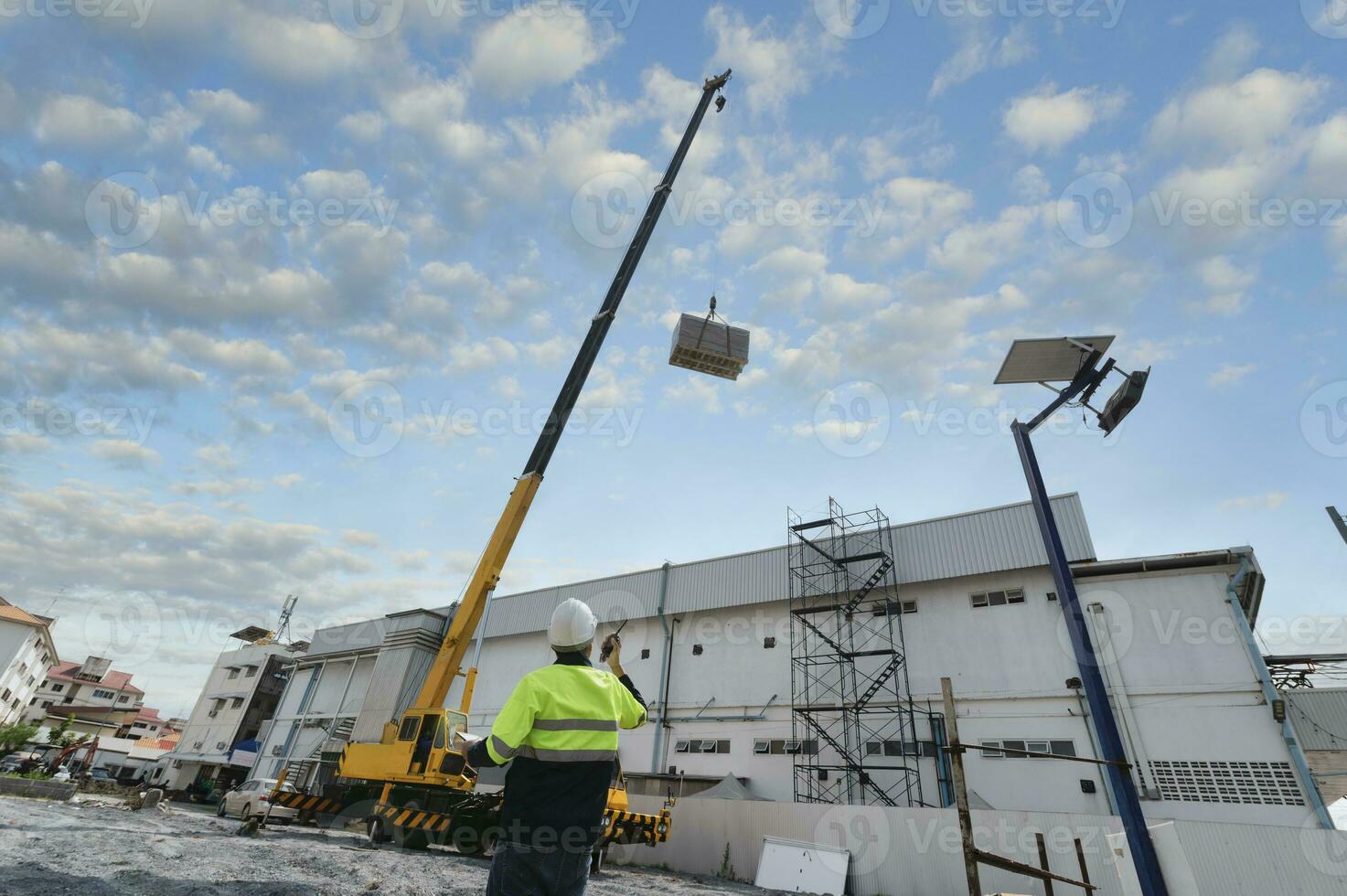 Industrial crane working and lifting power generator under sunlight and blue sky, heavy equipment crane photo