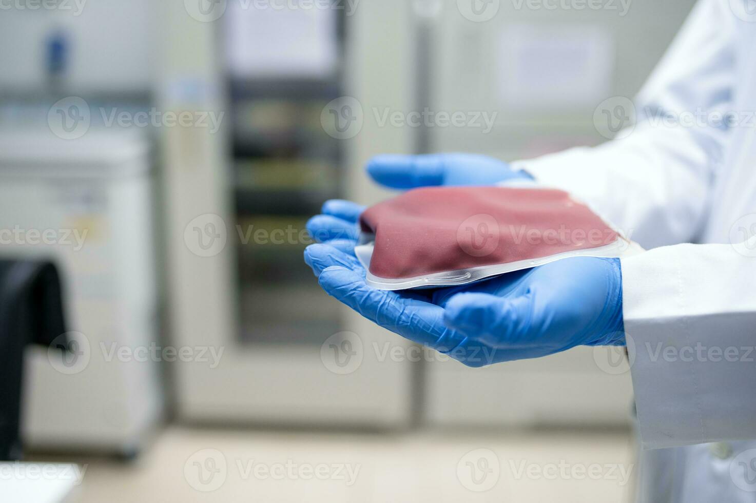 Doctor's hand holding blood bag in laboratory technician analyzing blood bag in blood bank photo