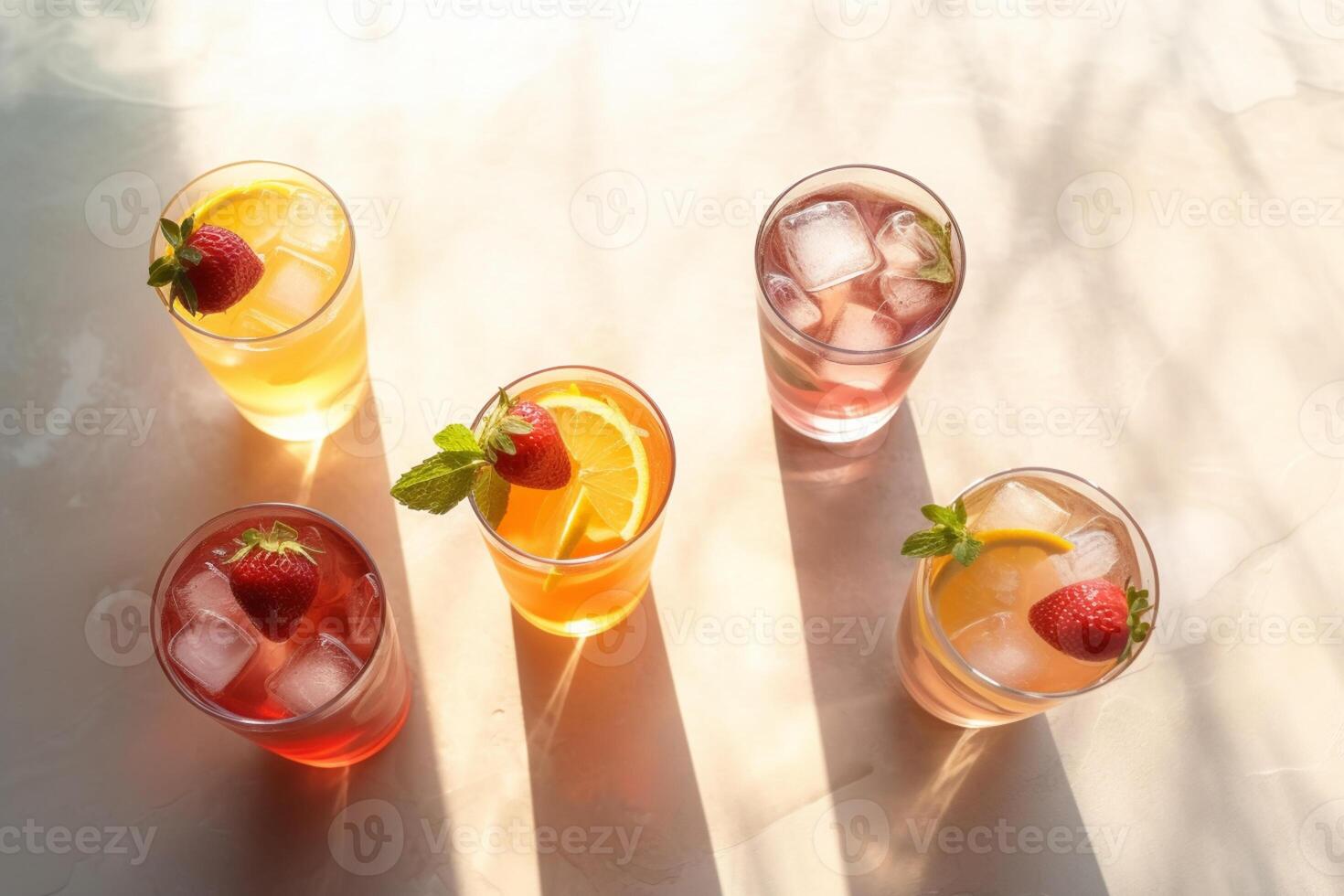 Summer cocktail in the sun. Fresh juicy drink in glass with shadow make trendy pattern on gray background. photo