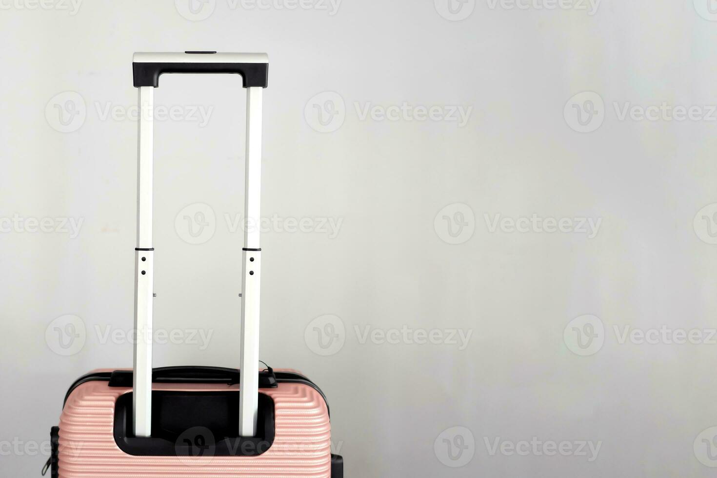 Closeup of peach luggage bag, minimalist travel concept in peach color. Luggage cabin size trolley, gray blank background with space for text, vacation trip, luggage suitcase photo