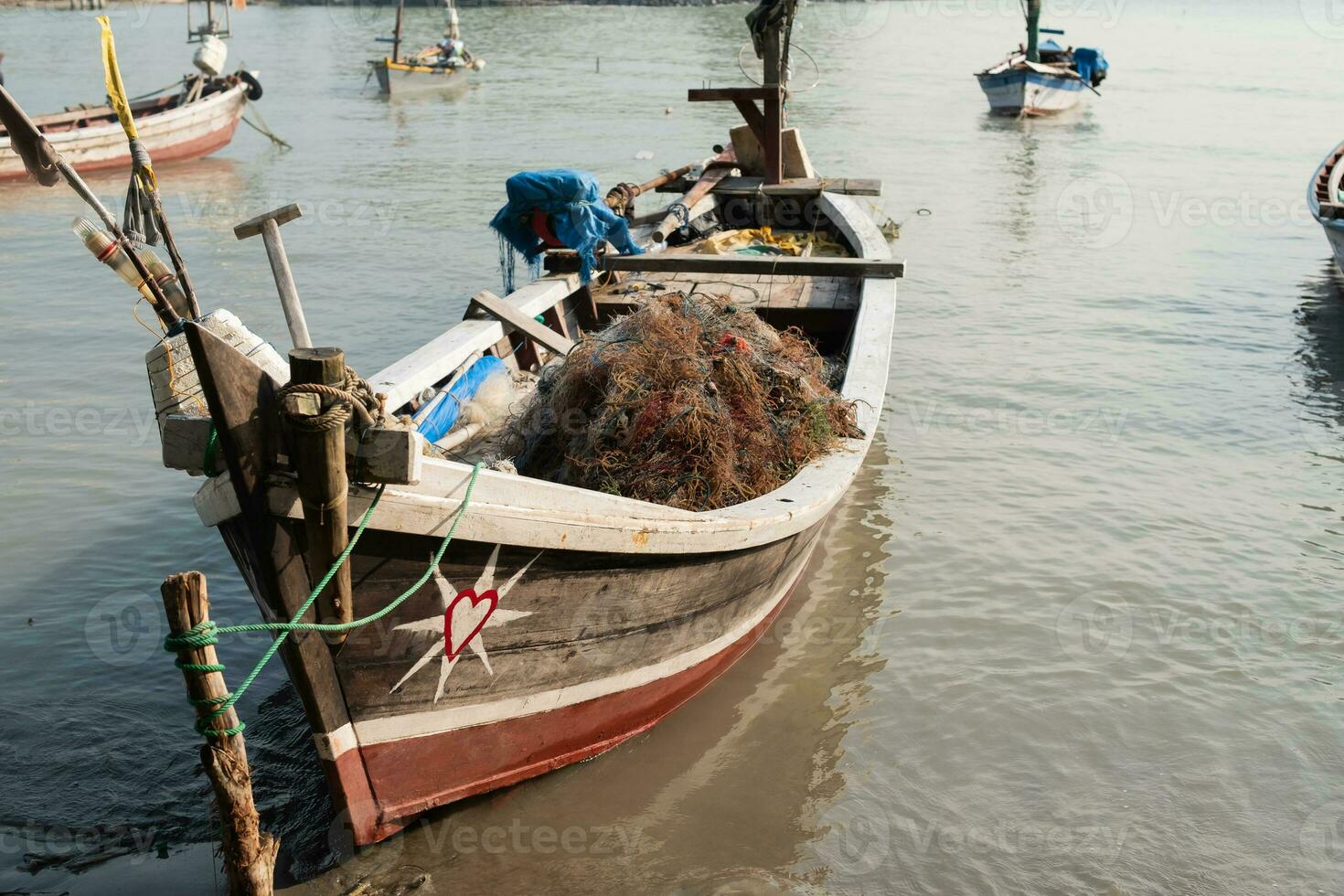 Pile of fishing nets and seaweed on a boat on a pier photo