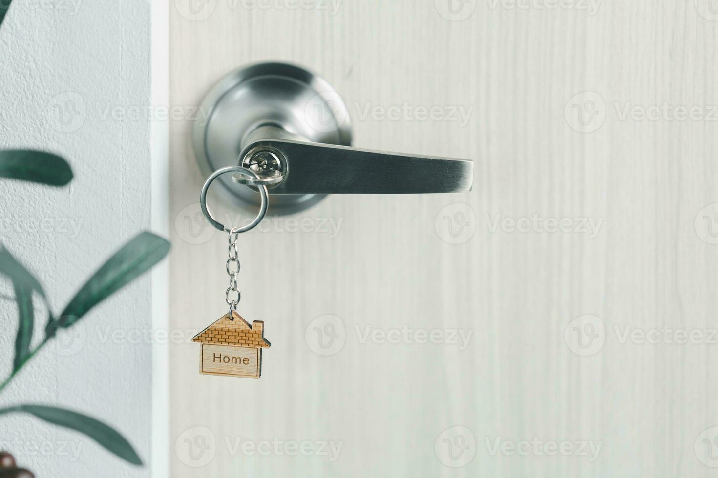 close up key on the door with morning light, personal loan concept. House model and key in house door. Real estate agent offer house, property insurance and security, affordable housing concepts. photo