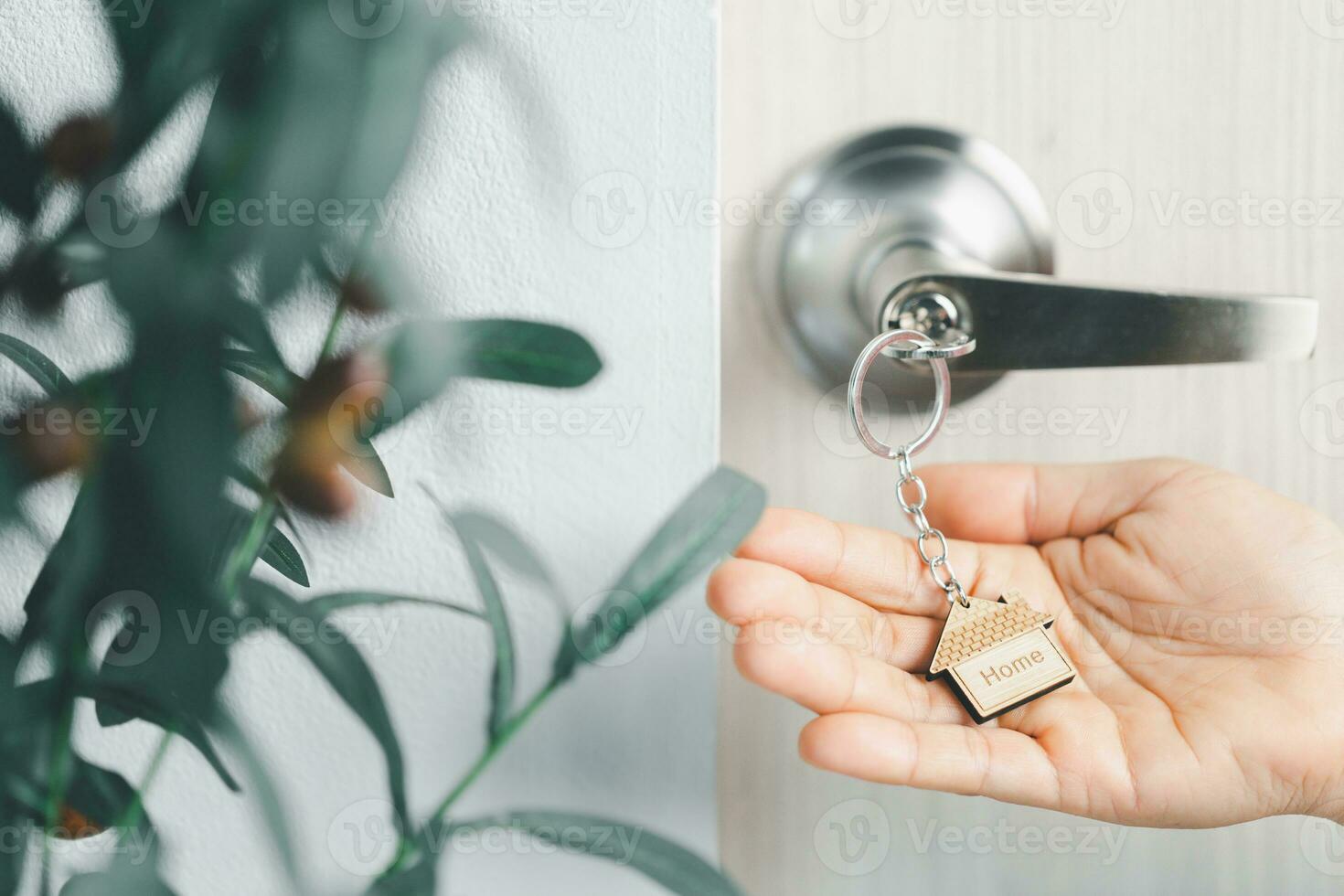 close up key on the door with morning light, personal loan concept. House model and key in house door. Real estate agent offer house, property insurance and security, affordable housing concepts. photo