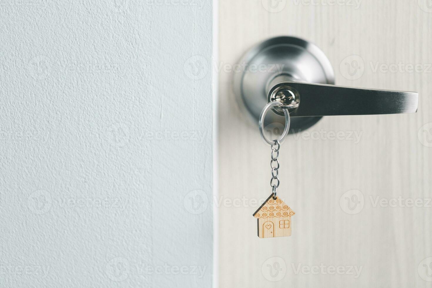 close up key on the door with morning light, personal loan concept. House model and key in house door. Real estate agent offer house, property insurance and security, affordable housing concepts. photo