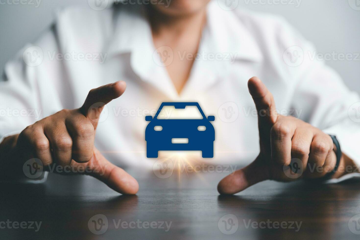 Business woman's hand protecting blue icon car on desk. Planning to manage transportation finance costs. Concept of car insurance business, saving buy - sale with tax and loan for new car. photo