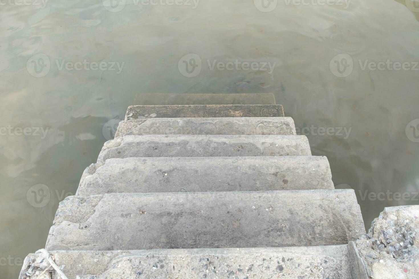 cemento escalera extendido dentro el agua. foto