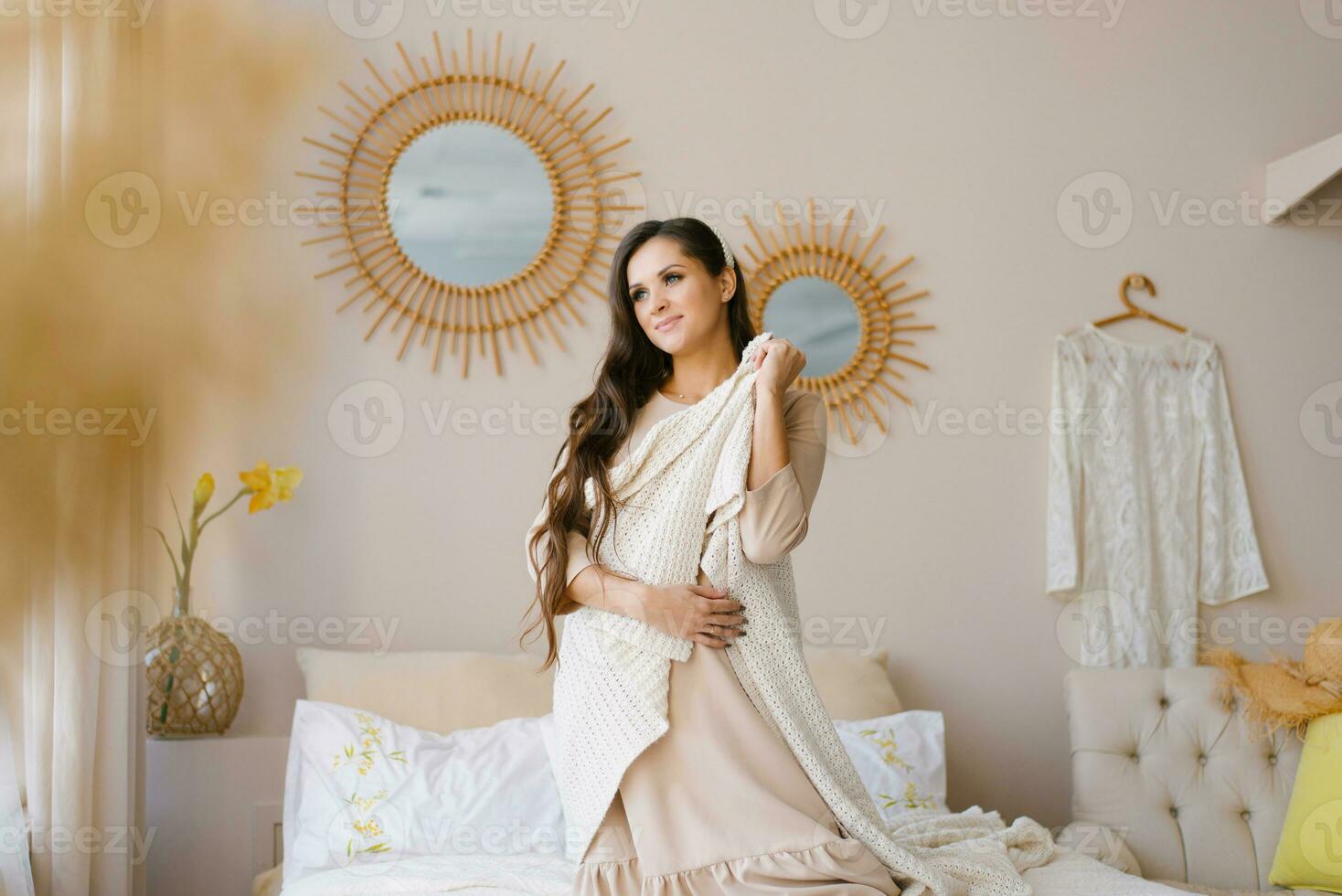 linda joven embarazada mujer es sentado en el cama esperando para el nacimiento de un bebé foto