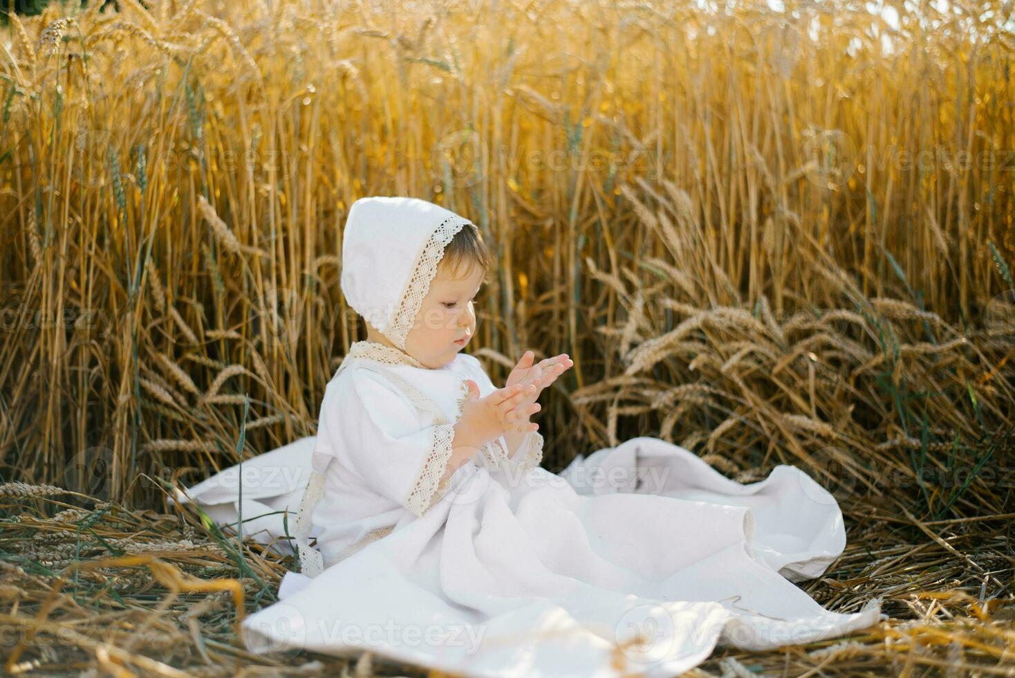 A child boy in white clothes is relaxing in the fresh air in a field photo