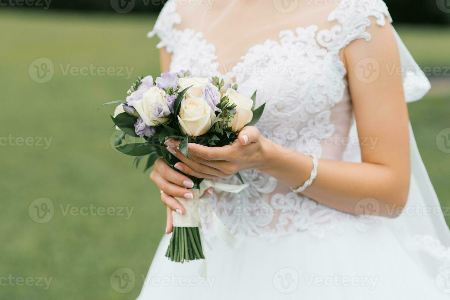 el ramo de boda de la novia de rosas de leche y eustoms lila en manos del primer plano de la novia foto