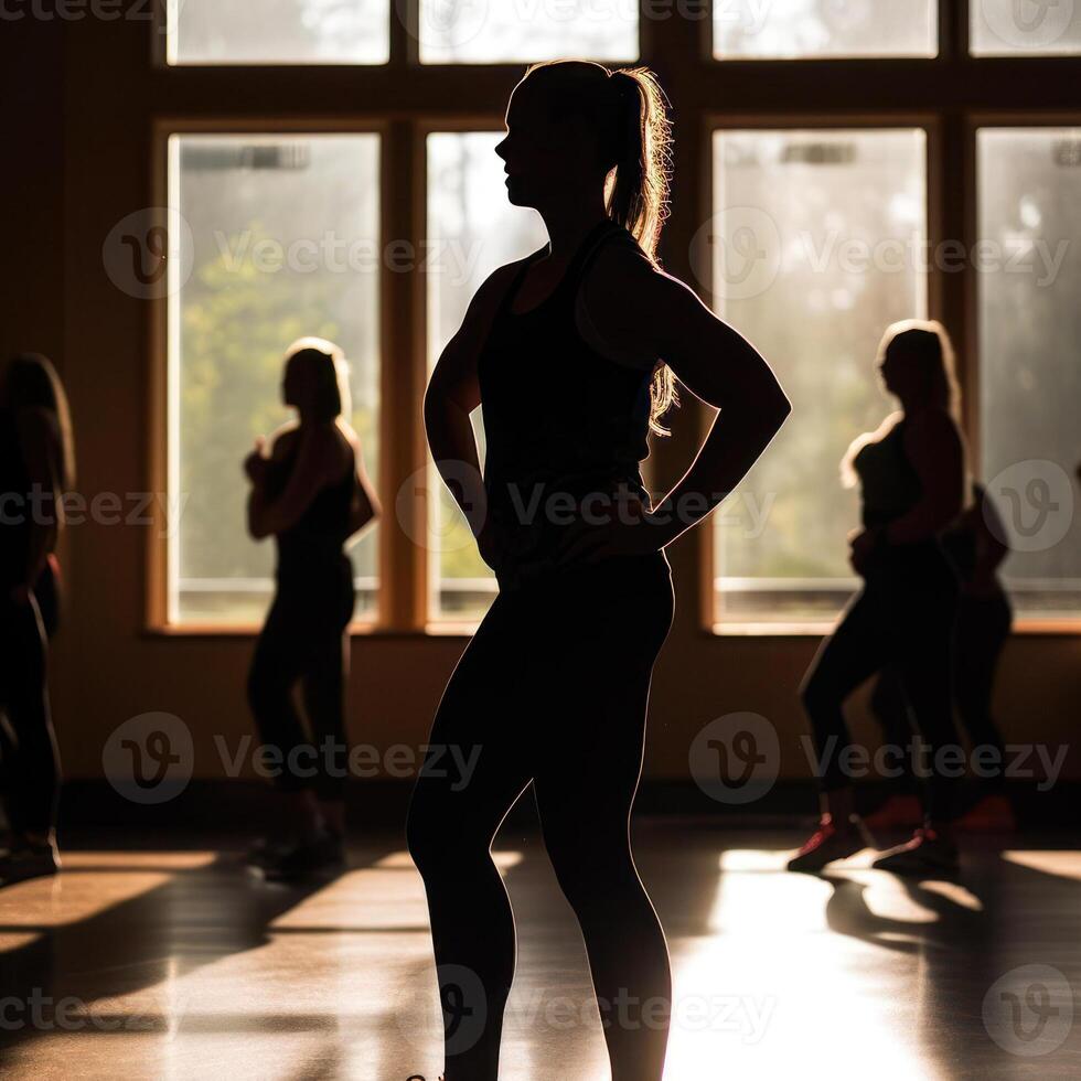 female fitness in the gym, silhouettes of women involved in sports with sundown background photo