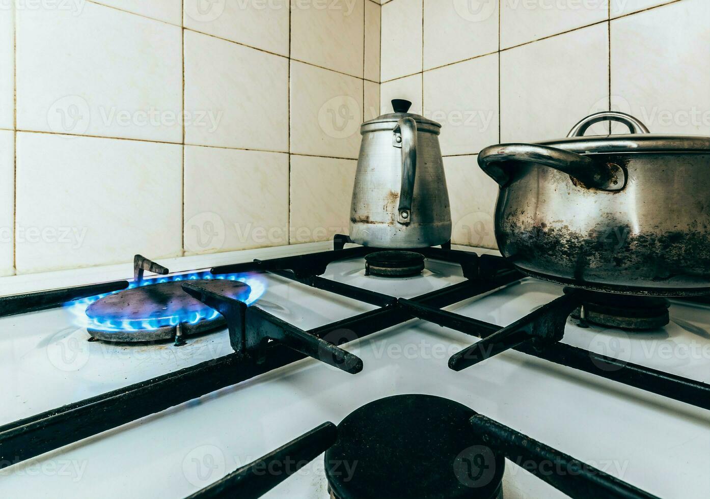 Natural gas burning on stove with pots and pans in the kitchen photo