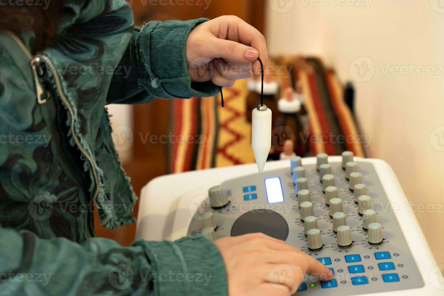 Close-up detail of a woman's hand holding a pendulum on a radionic machine. Alternative medicine. Medicine and science photo