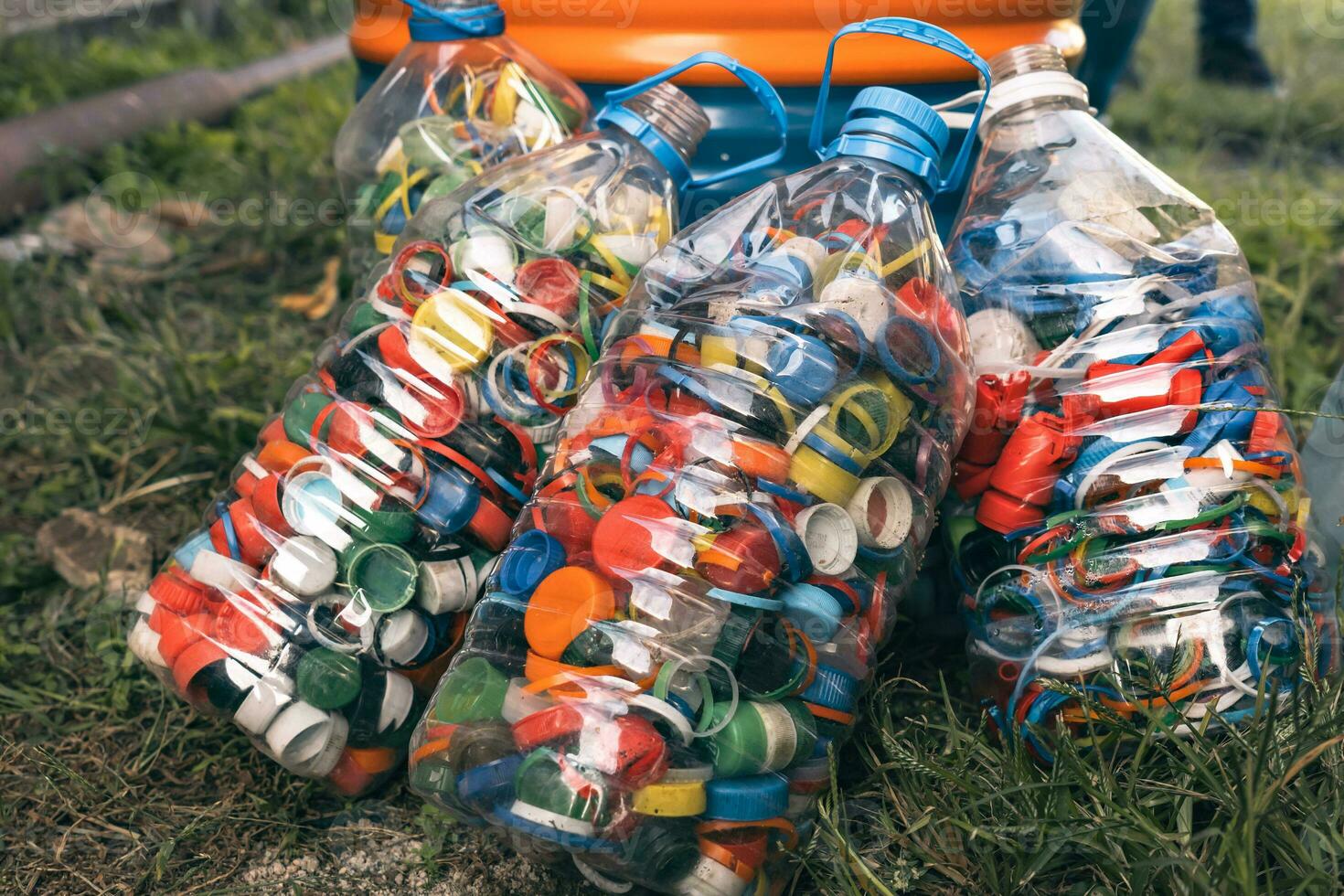 Detail of large quantity of colored plastic bottle caps. Recycling Center. photo