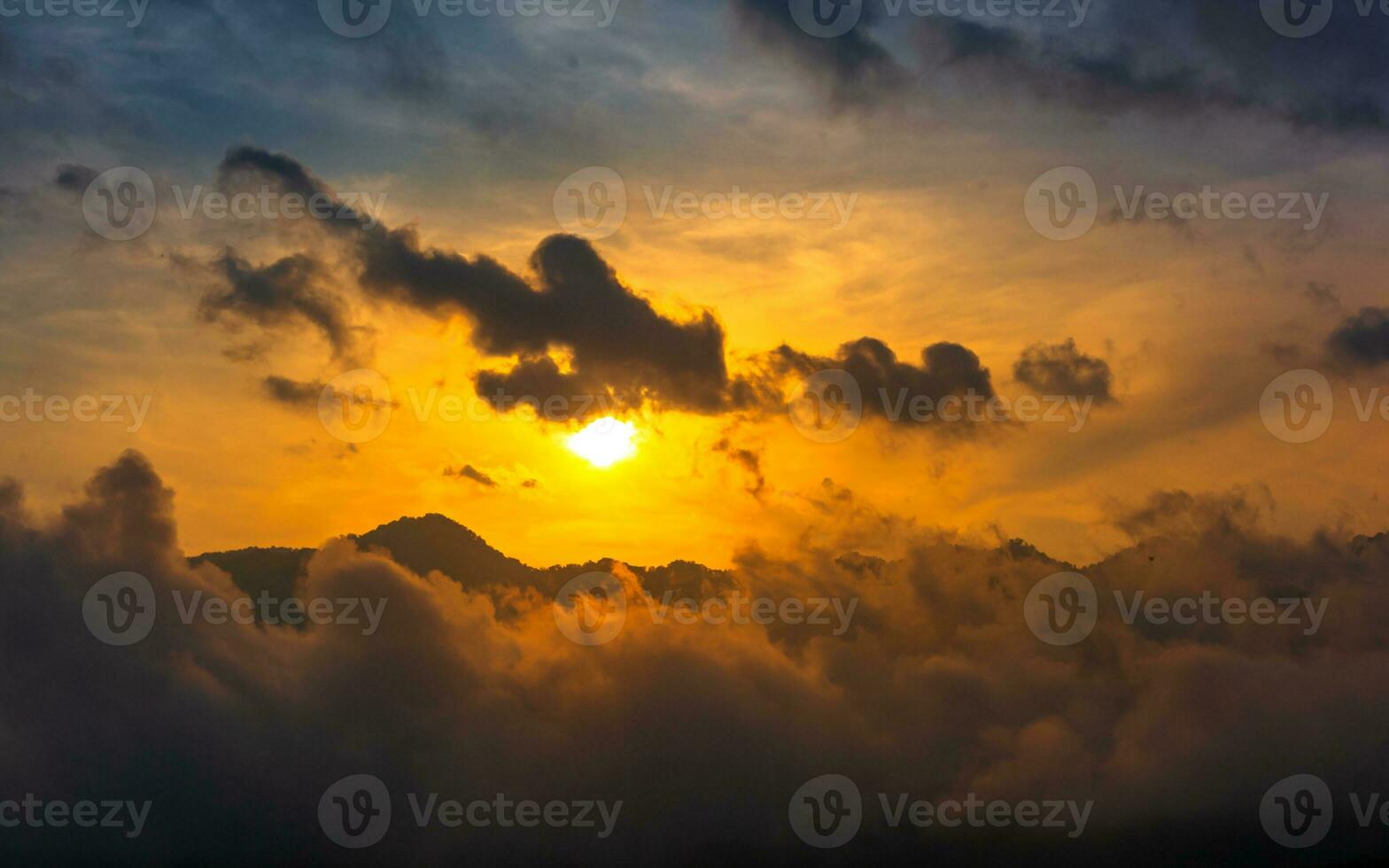 Beautiful dramatic sunset sky over mountain with clouds photo