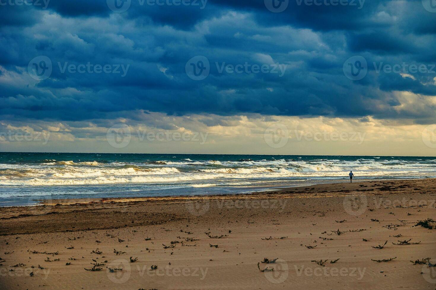 beach by the sea and a lonely runner on the shore landscape photo