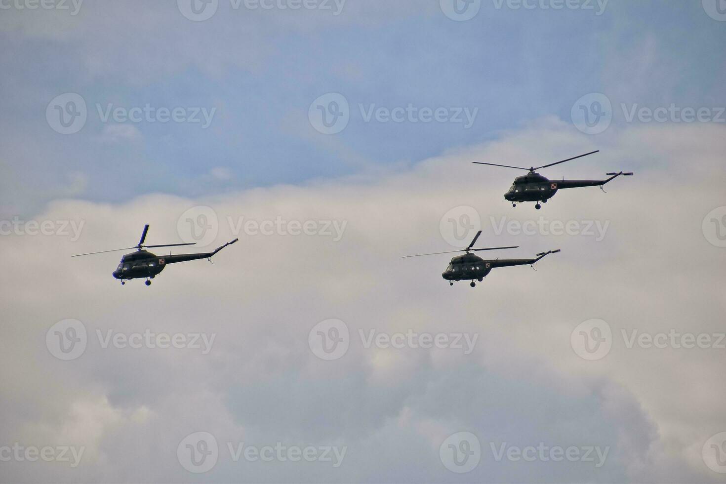 flying combat helicopters against a blue sky with clouds on a sunny day photo