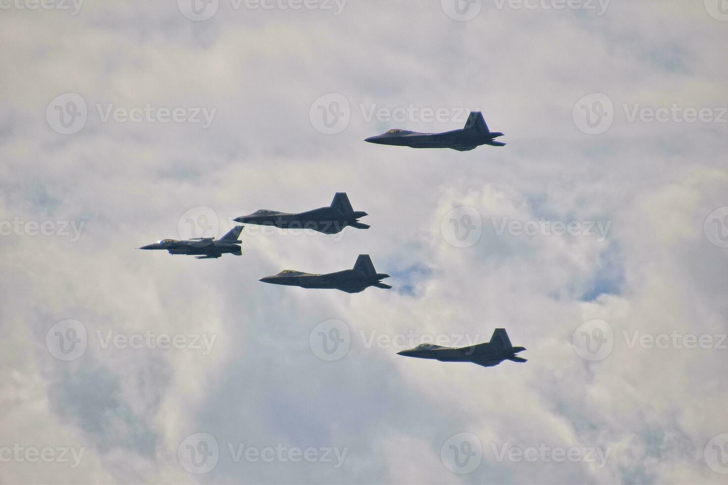 flying combat aircraft against the blue sky with clouds on a sunny day photo