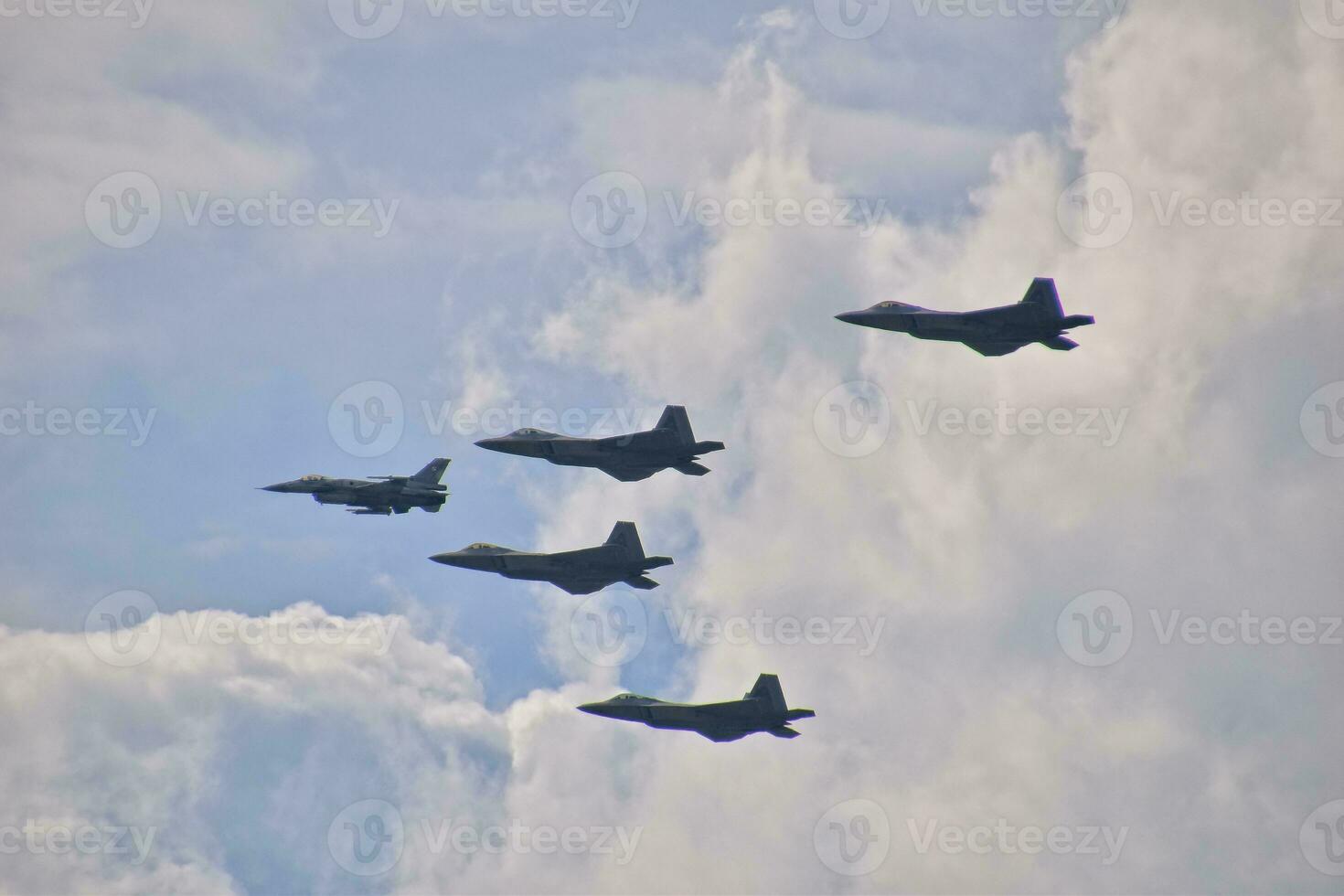 flying combat aircraft against the blue sky with clouds on a sunny day photo