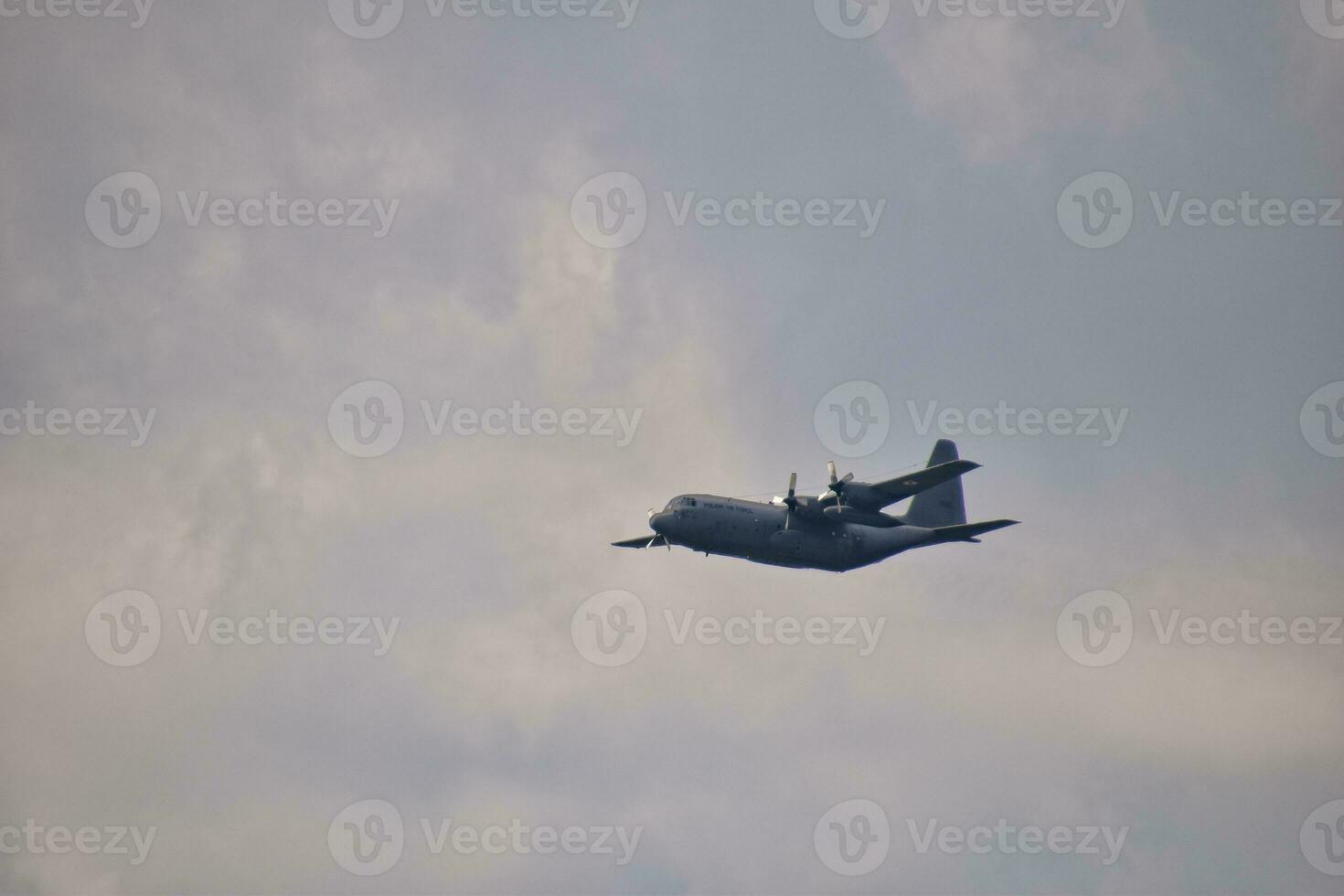 flying combat aircraft against the blue sky with clouds on a sunny day photo