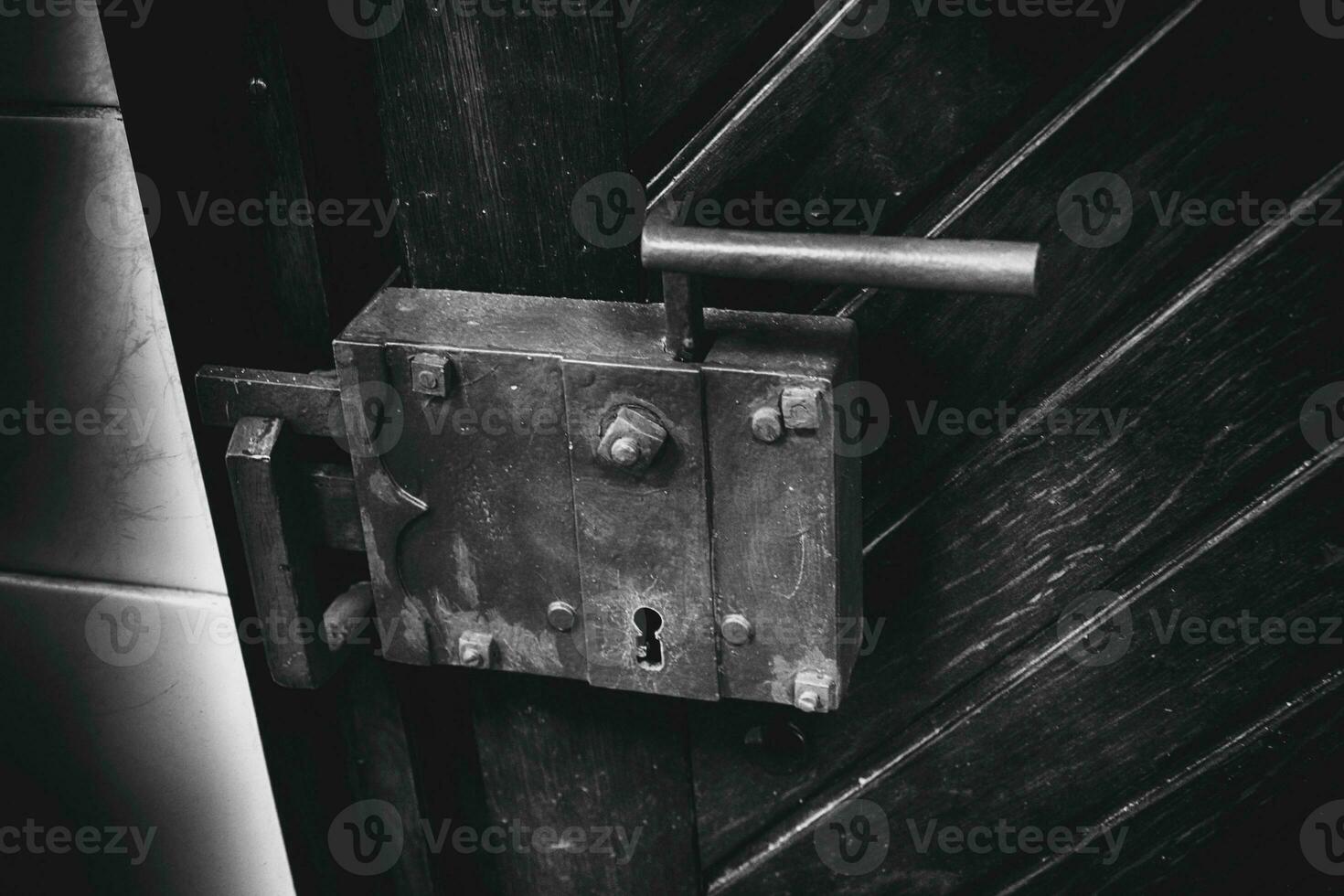 old antique lock with a handle in a wooden door close-up in the building photo