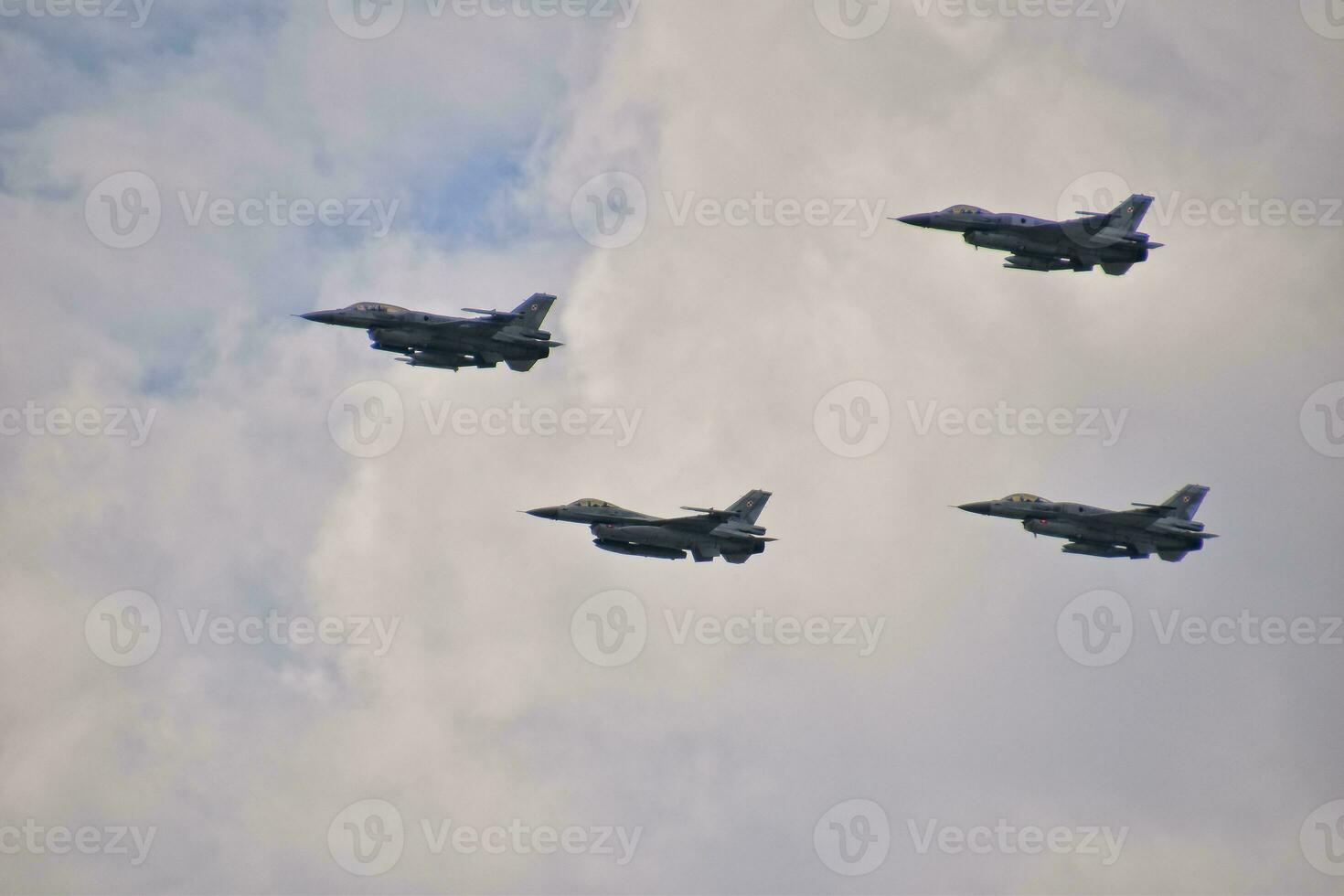 flying combat aircraft against the blue sky with clouds on a sunny day photo