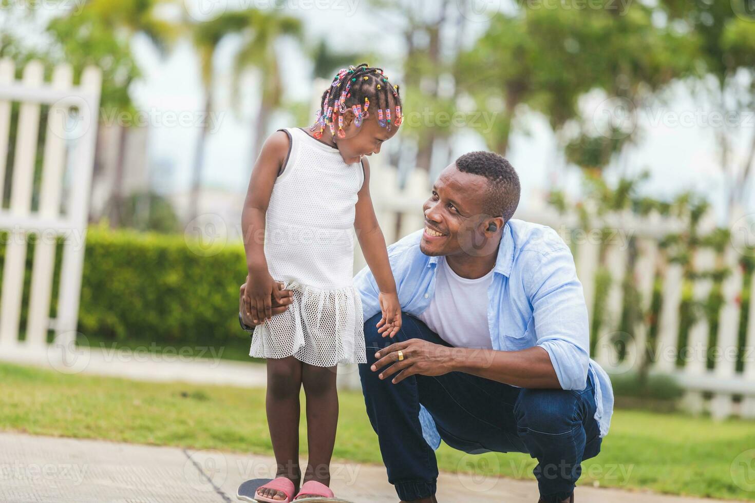 del padre día concepto, padre Ayudar su pequeño hija a paseo un patineta, pequeño niña y su padre jugando con patineta al aire libre foto