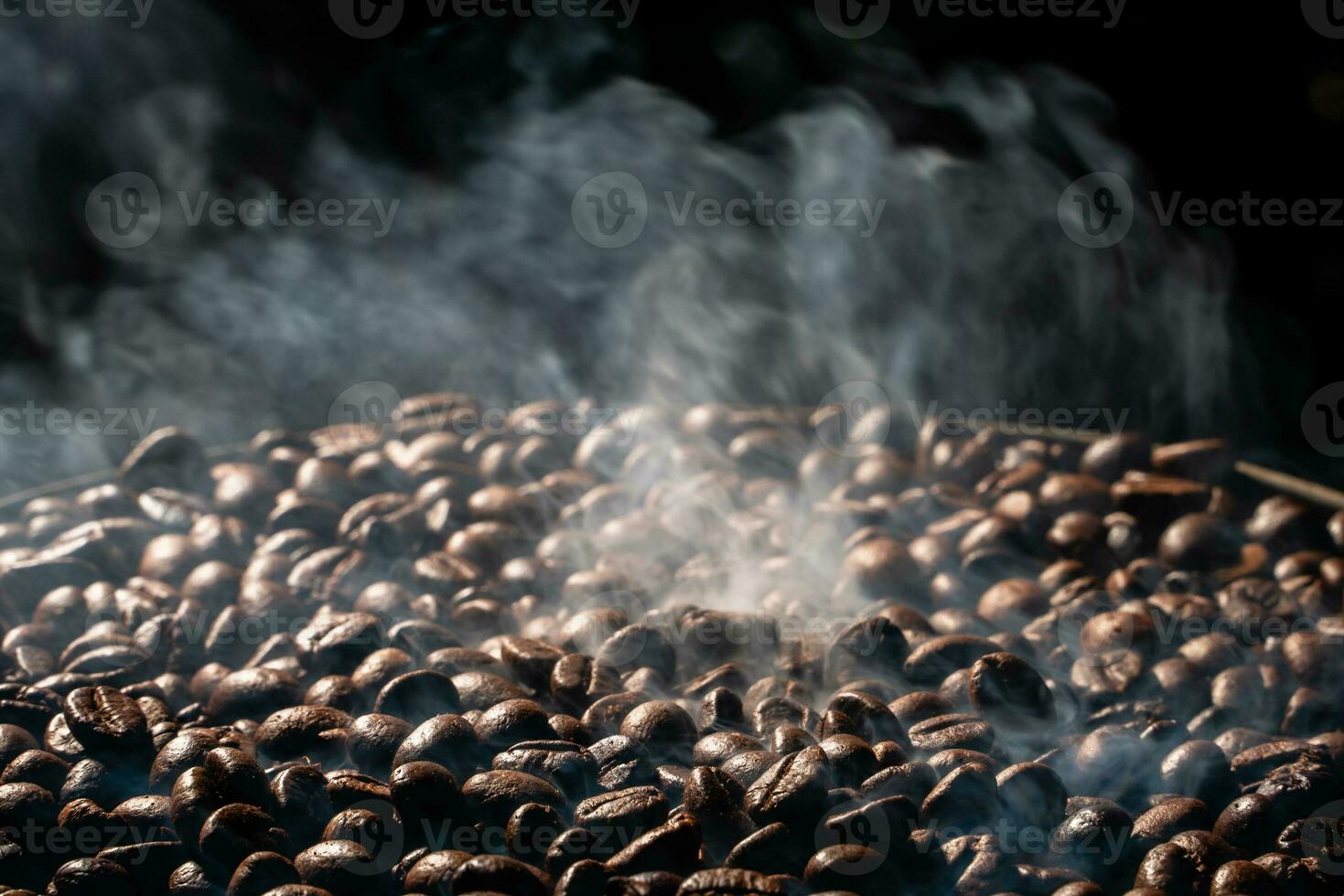 Coffee beans roasting with smoke,  selective focus, and soft focus. photo