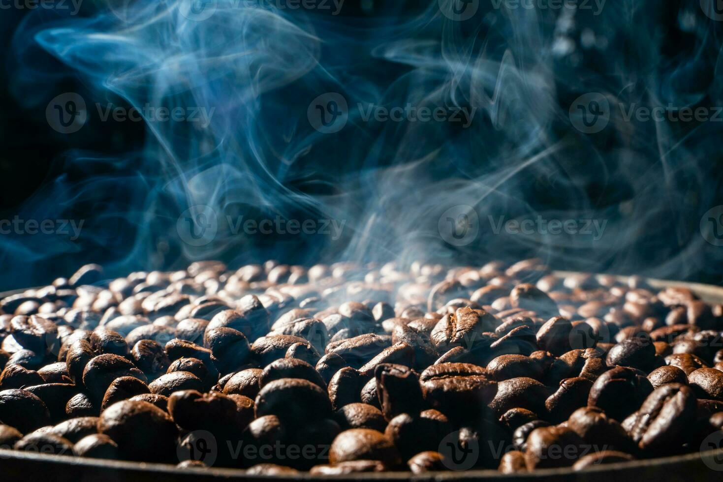 Coffee beans roasting with smoke,  selective focus, and soft focus. photo