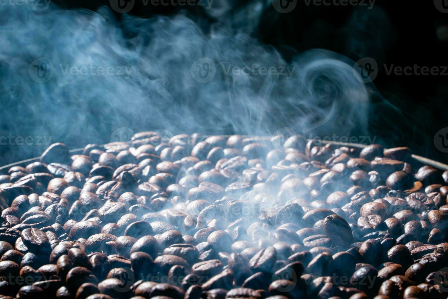 Coffee beans roasting with smoke,  selective focus, and soft focus. photo