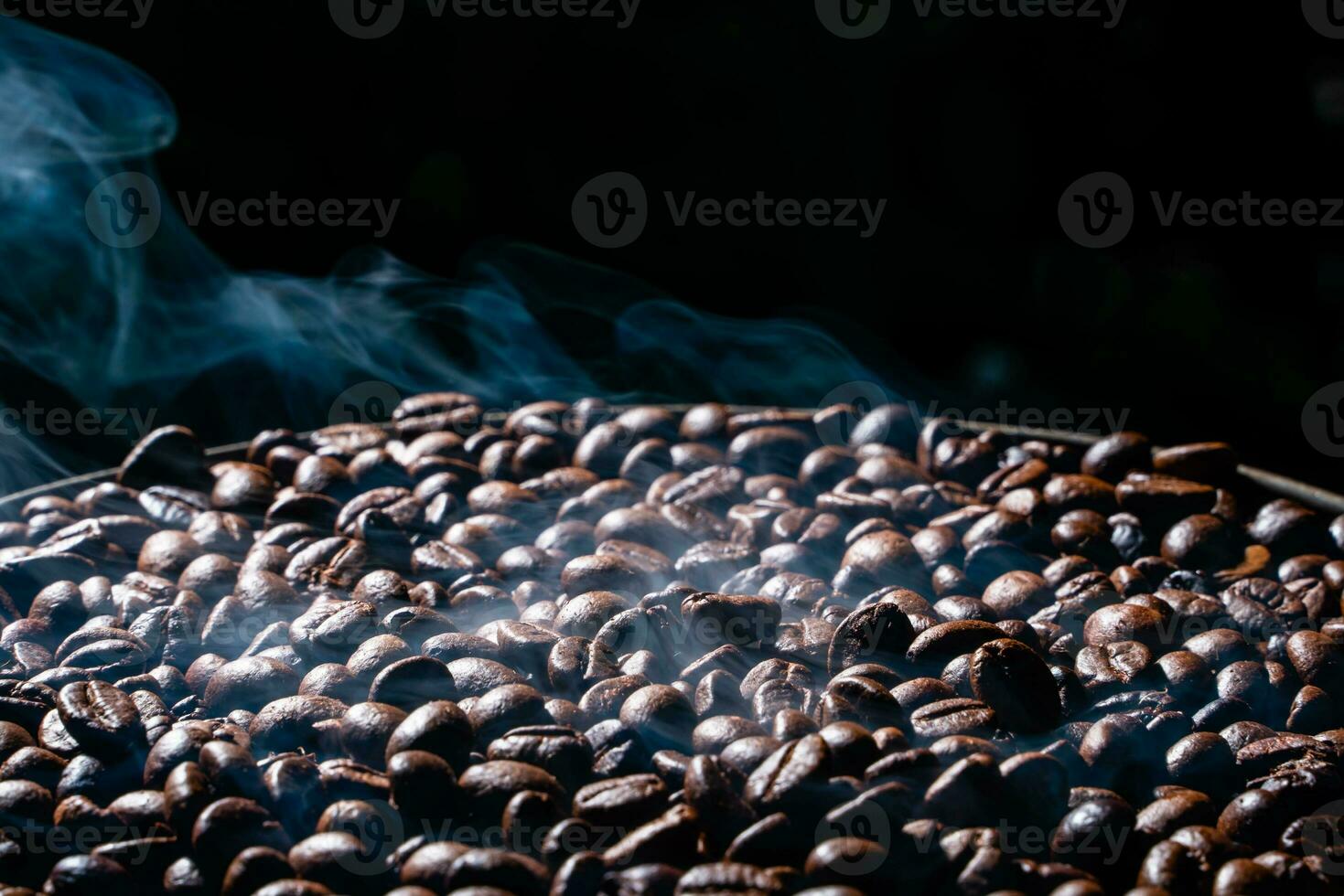 Coffee beans roasting with smoke,  selective focus, and soft focus. photo
