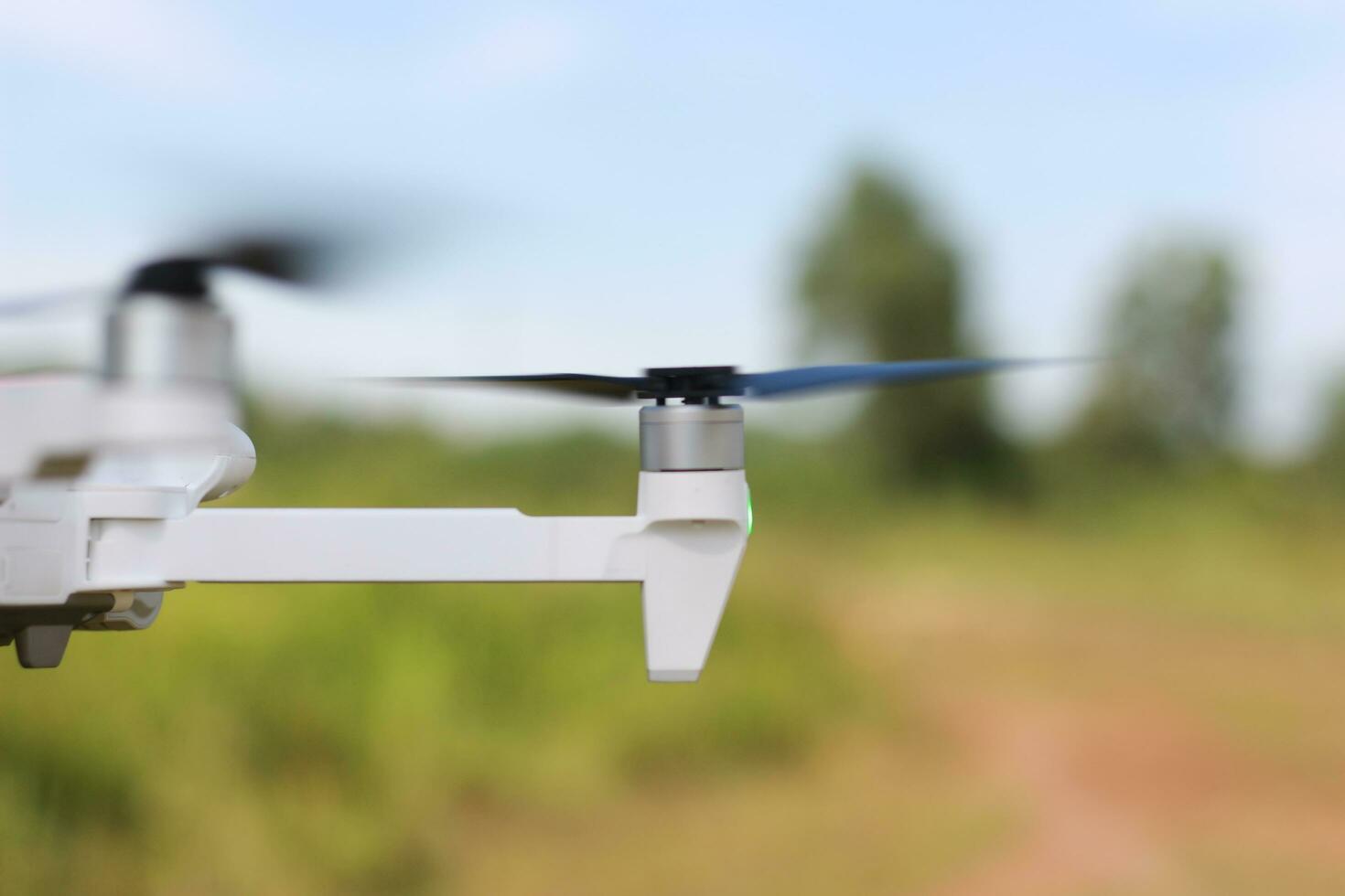 Bogor, Indonesia - 2022. a photo of a drone flying with a blurry propeller against a green open space background. technology photo concept.