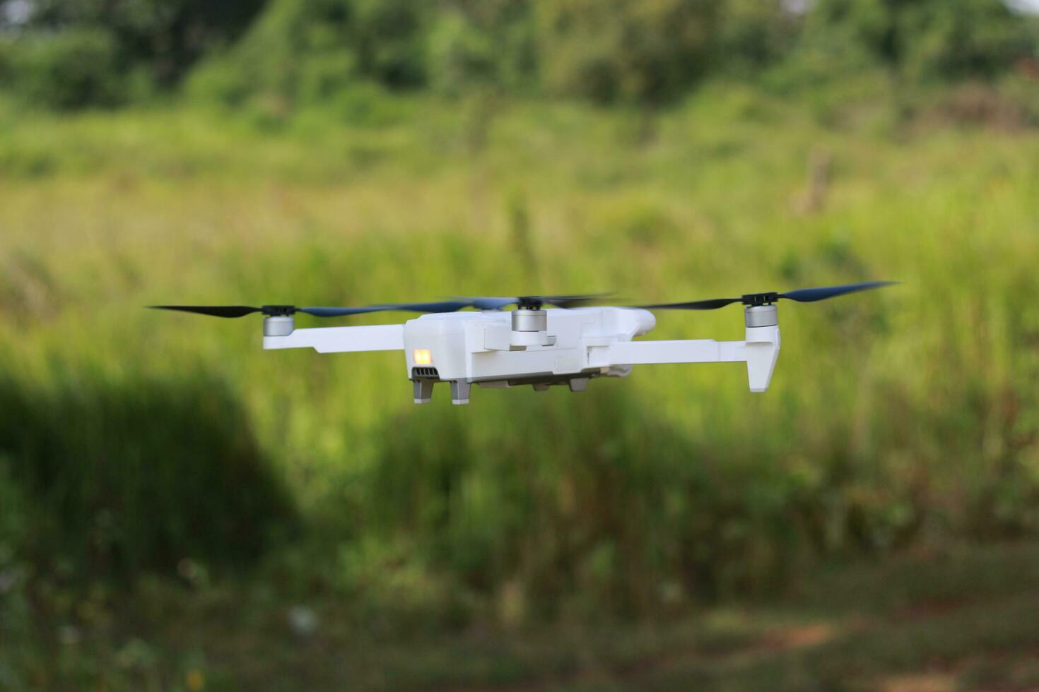 Bogor, Indonesia - 2022. a photo of a drone flying with a blurry propeller against a green open space background. technology photo concept.