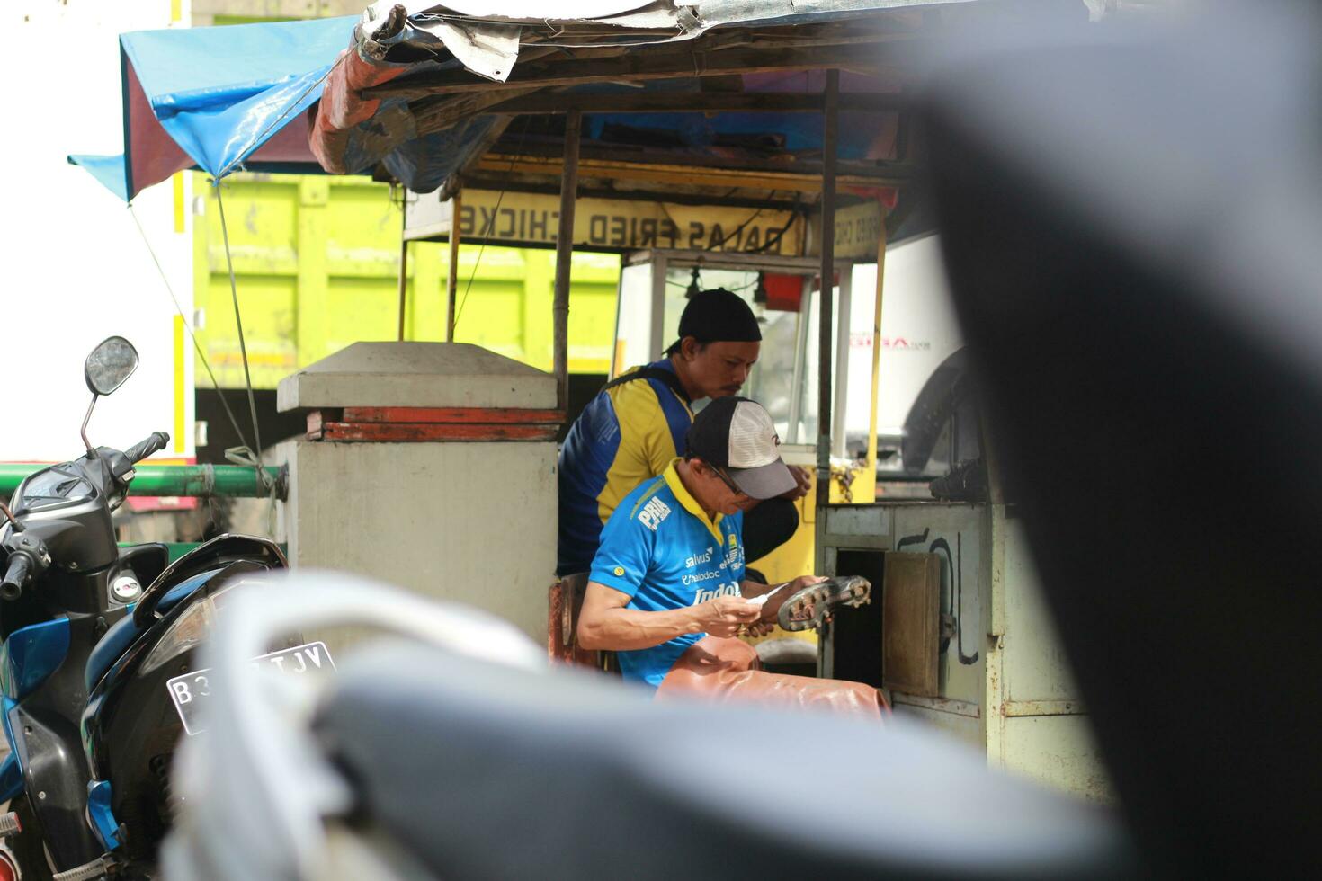 Bogor, Indonesia - 2022. shoe sole worker repairing shoes at a roadside stand. a unique profession from Indonesia. photo