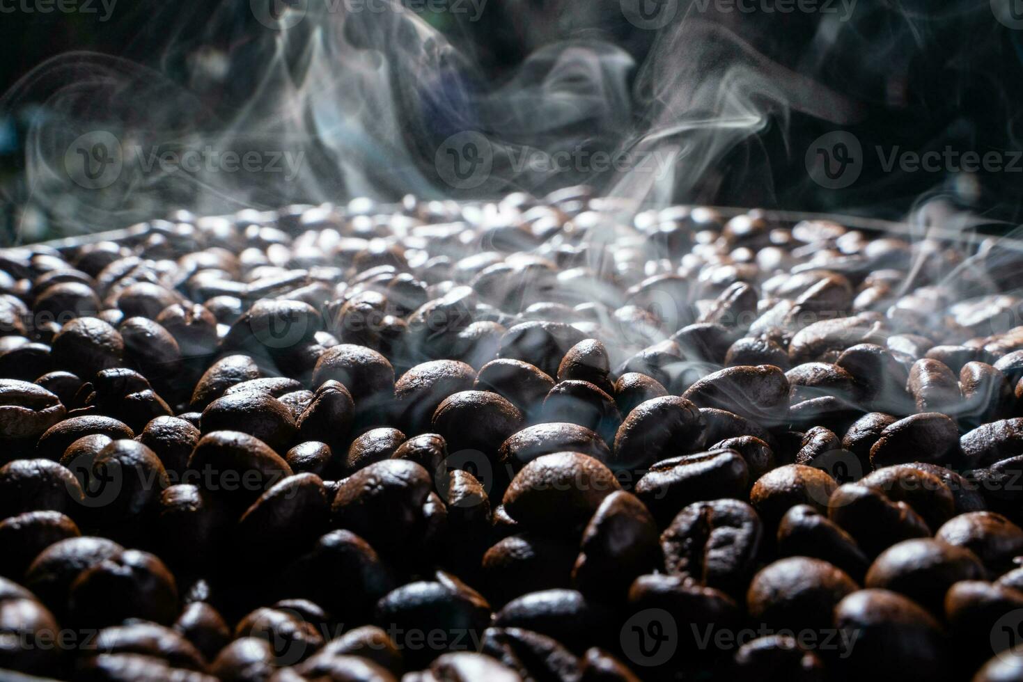 Coffee beans roasting with smoke,  selective focus, and soft focus. photo