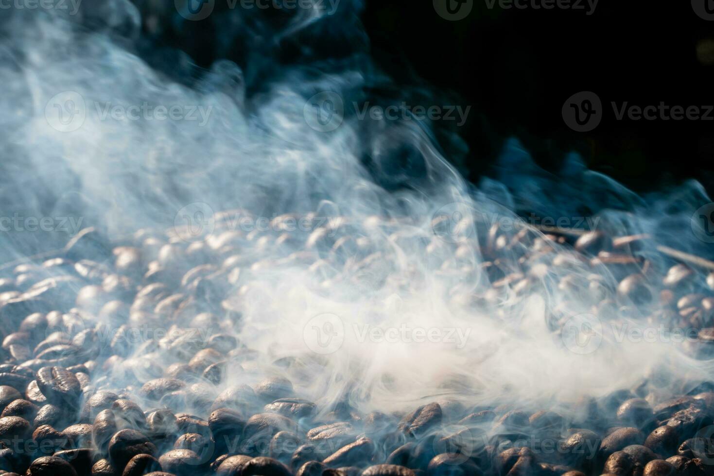 Coffee beans roasting with smoke,  selective focus, and soft focus. photo