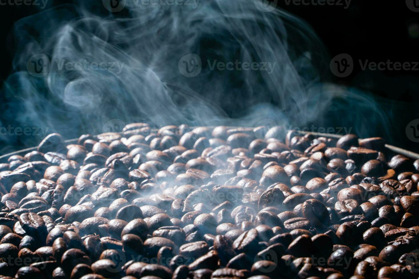 Coffee beans roasting with smoke,  selective focus, and soft focus. photo