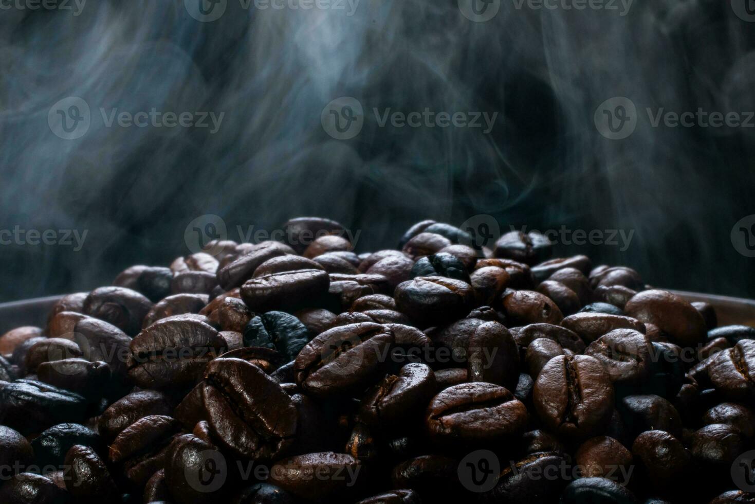 Coffee beans roasting with smoke,  selective focus, and soft focus. photo