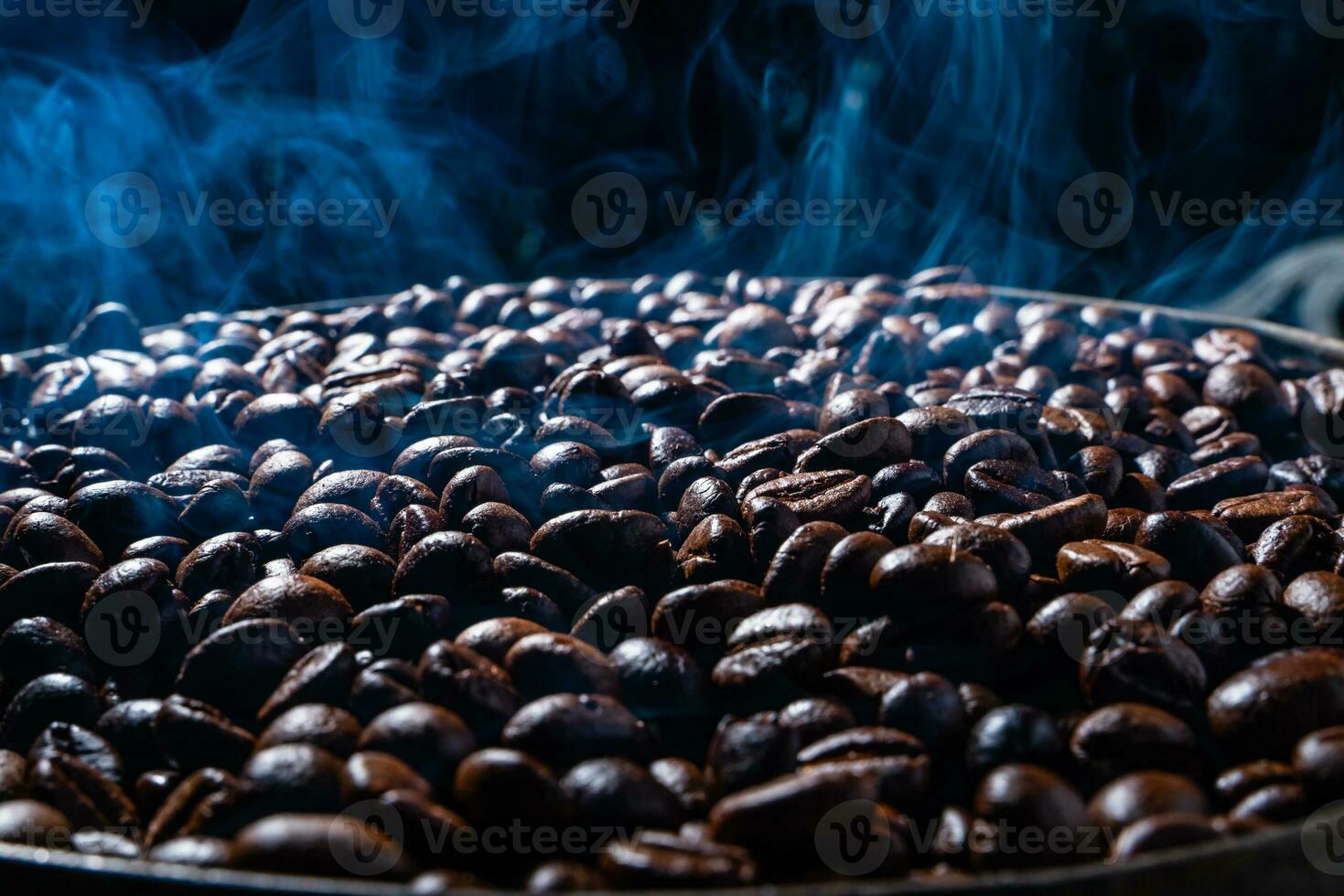 Coffee beans roasting with smoke,  selective focus, and soft focus. photo