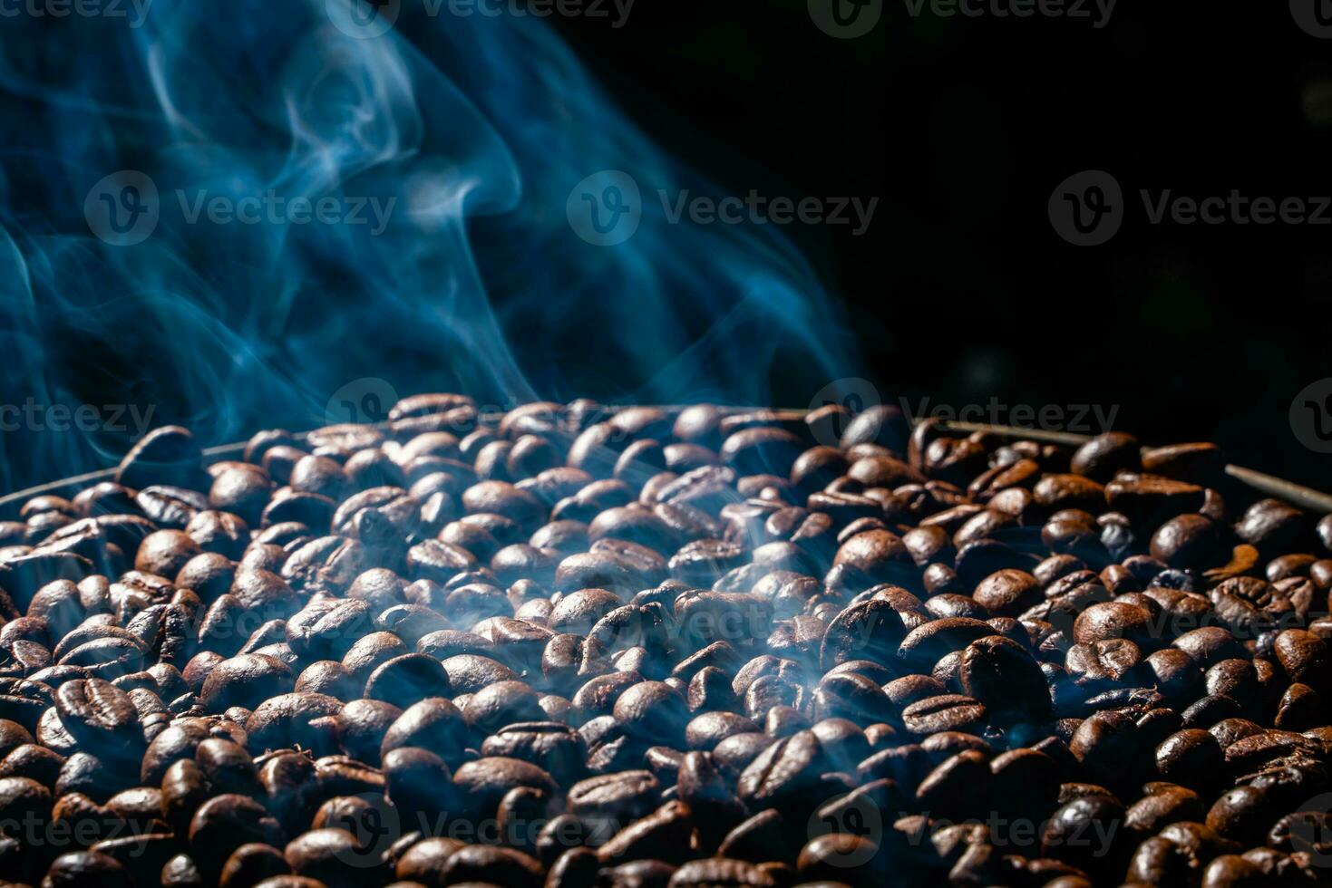 Coffee beans roasting with smoke,  selective focus, and soft focus. photo